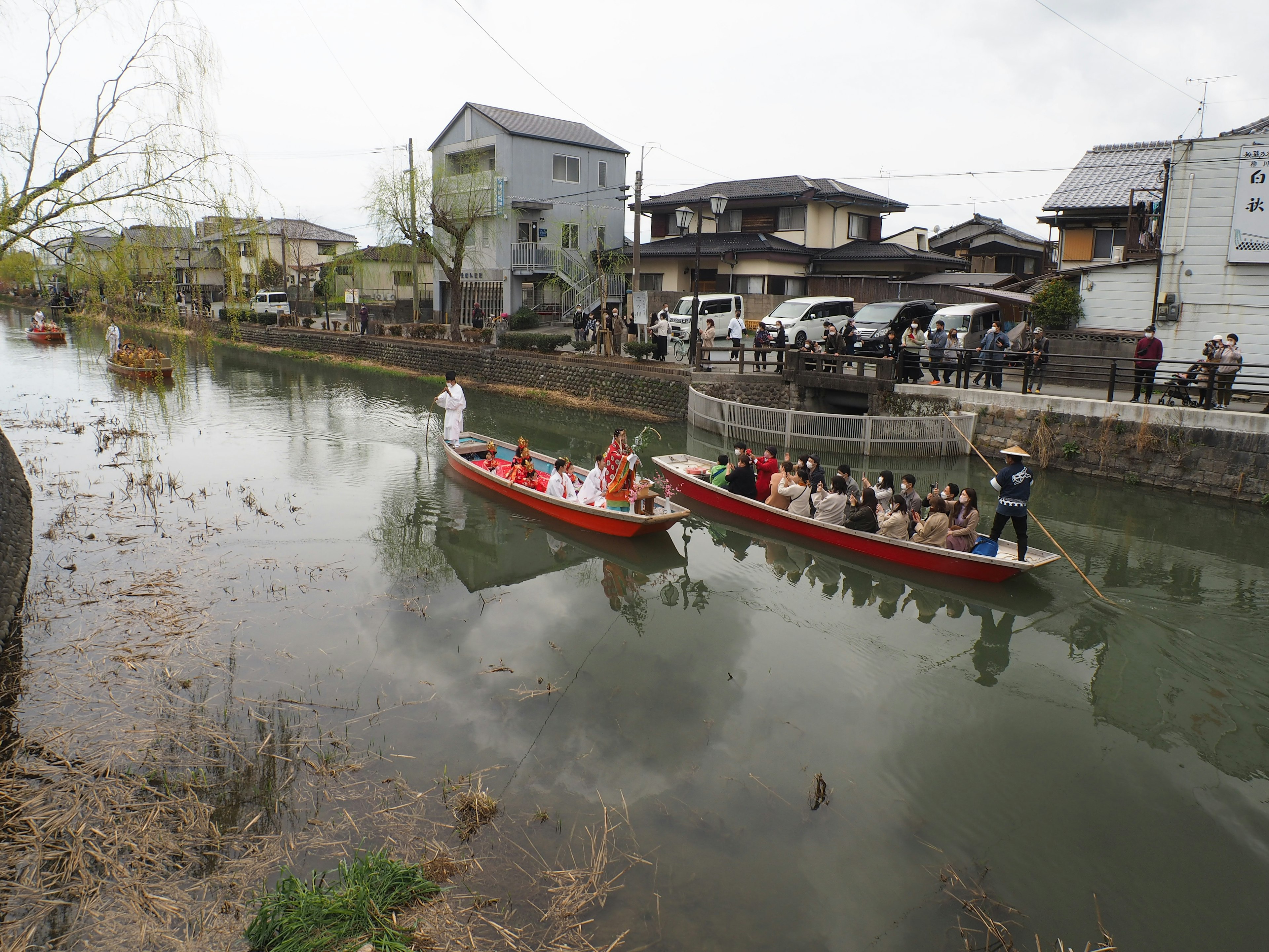 Touristenboote, die einen Fluss mit umliegenden Häusern befahren