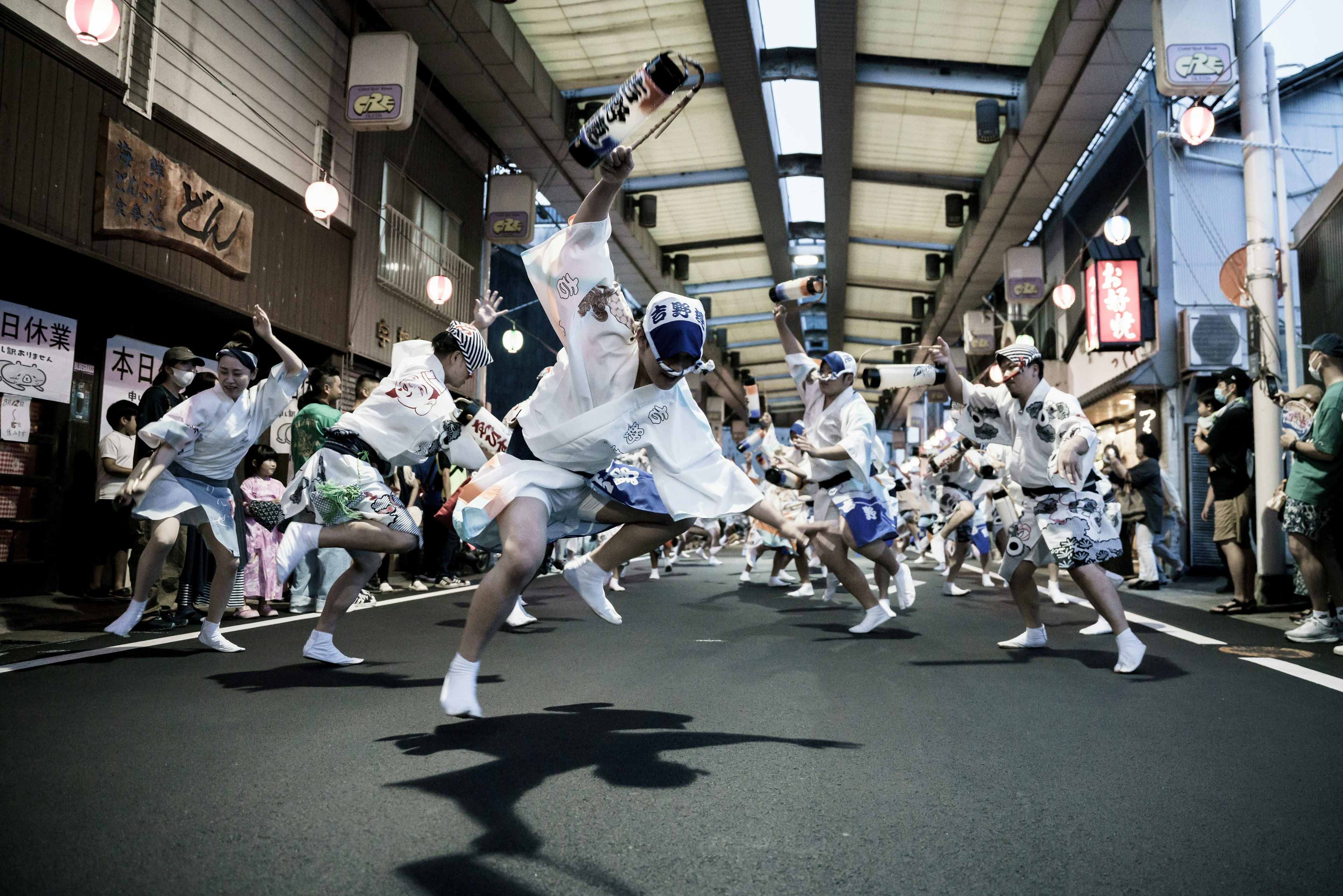 祭りで踊る人々が白い衣装を着ている活気あるシーン