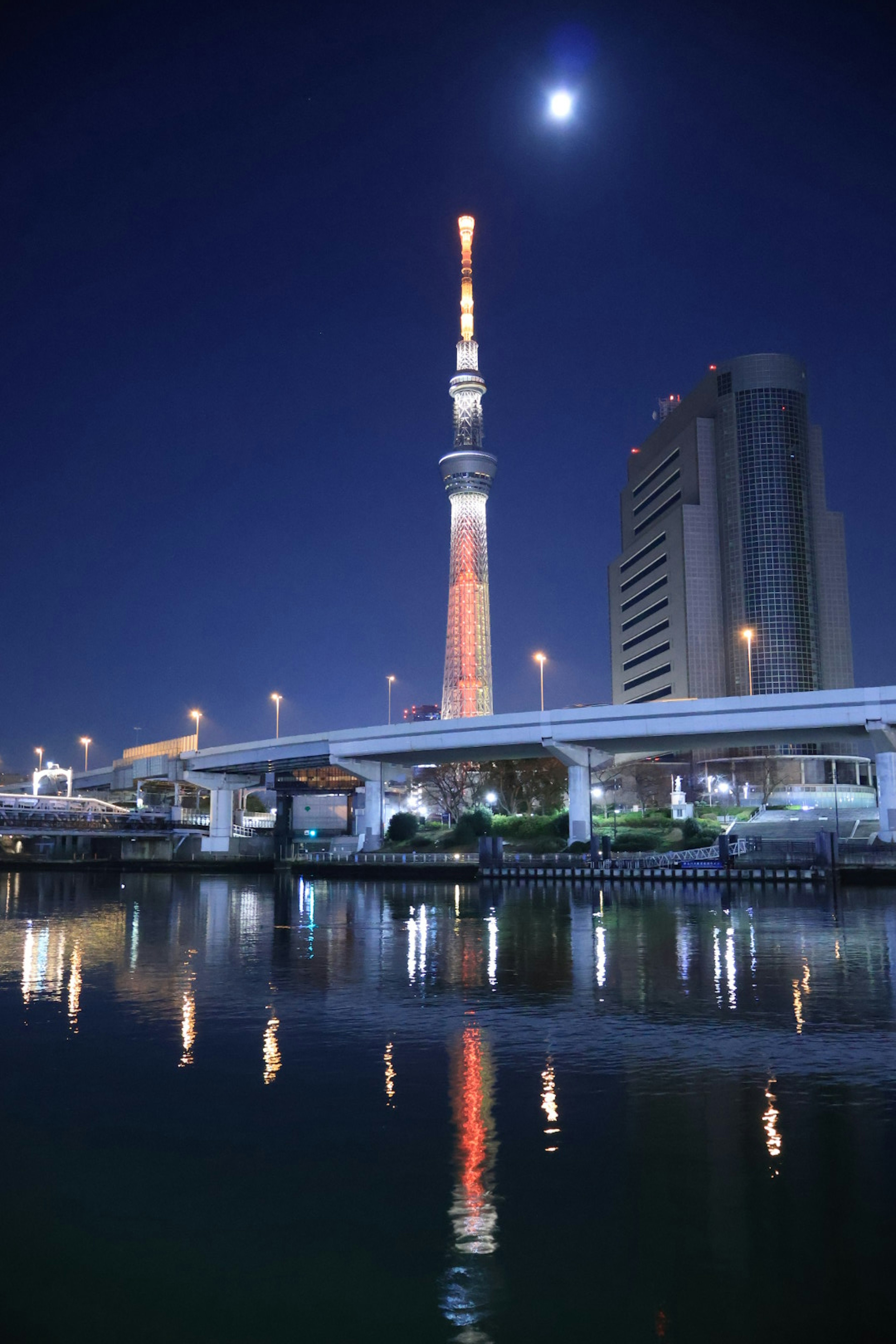 Tokyo Skytree sáng đèn vào ban đêm với mặt trăng sáng