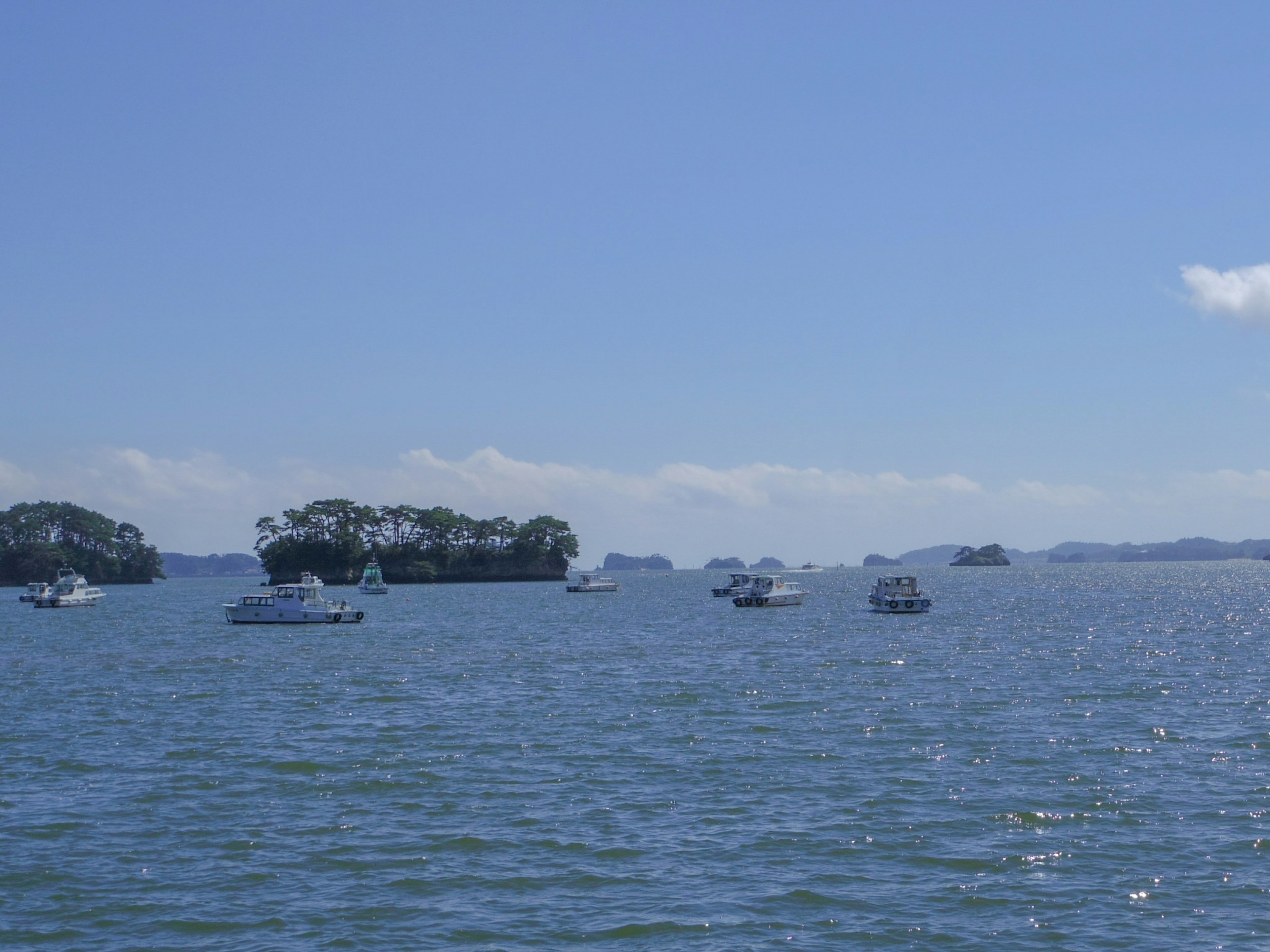 Vista escénica del mar azul con pequeños botes