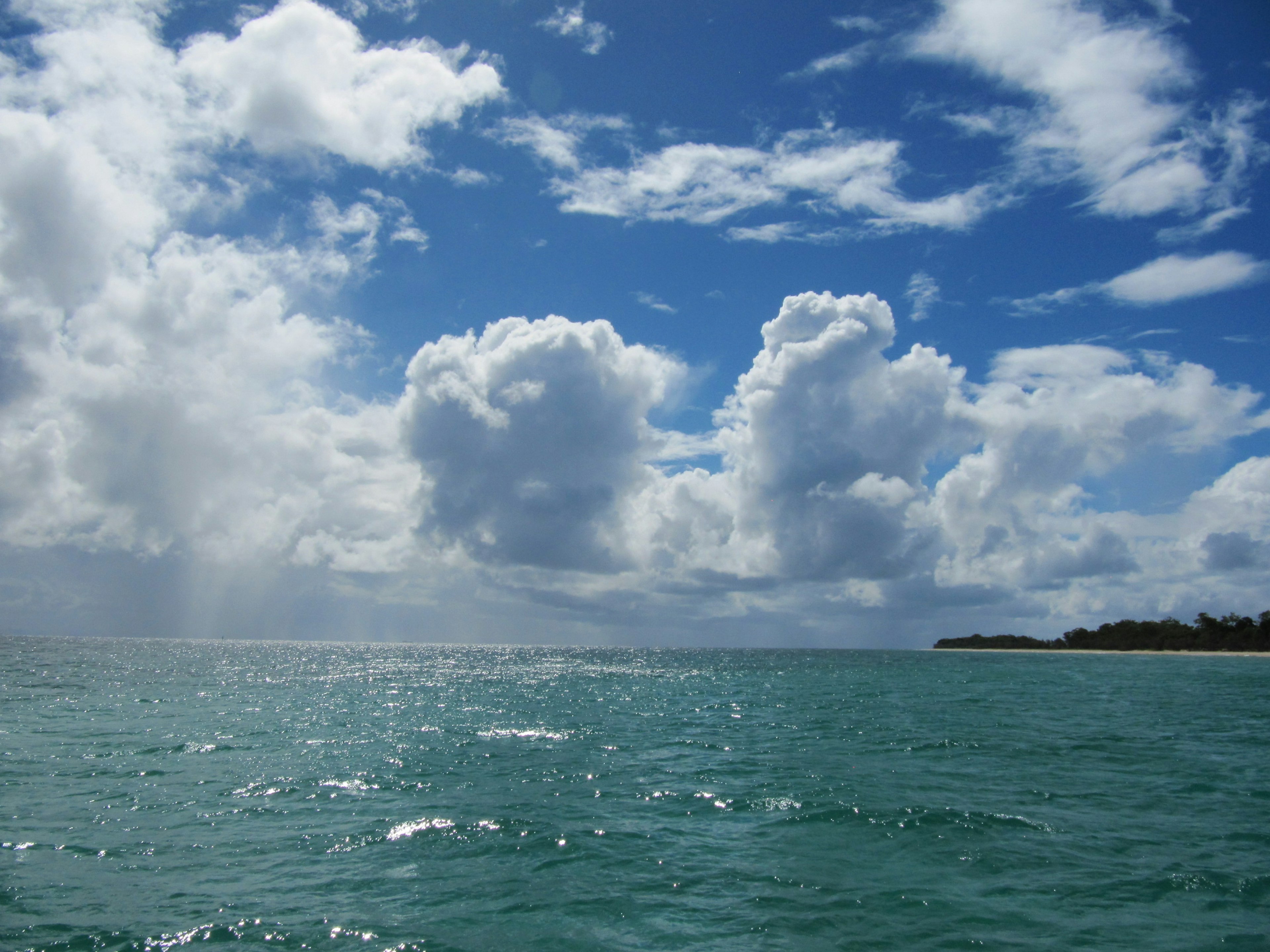 Vue panoramique de l'océan bleu avec des nuages blancs moelleux