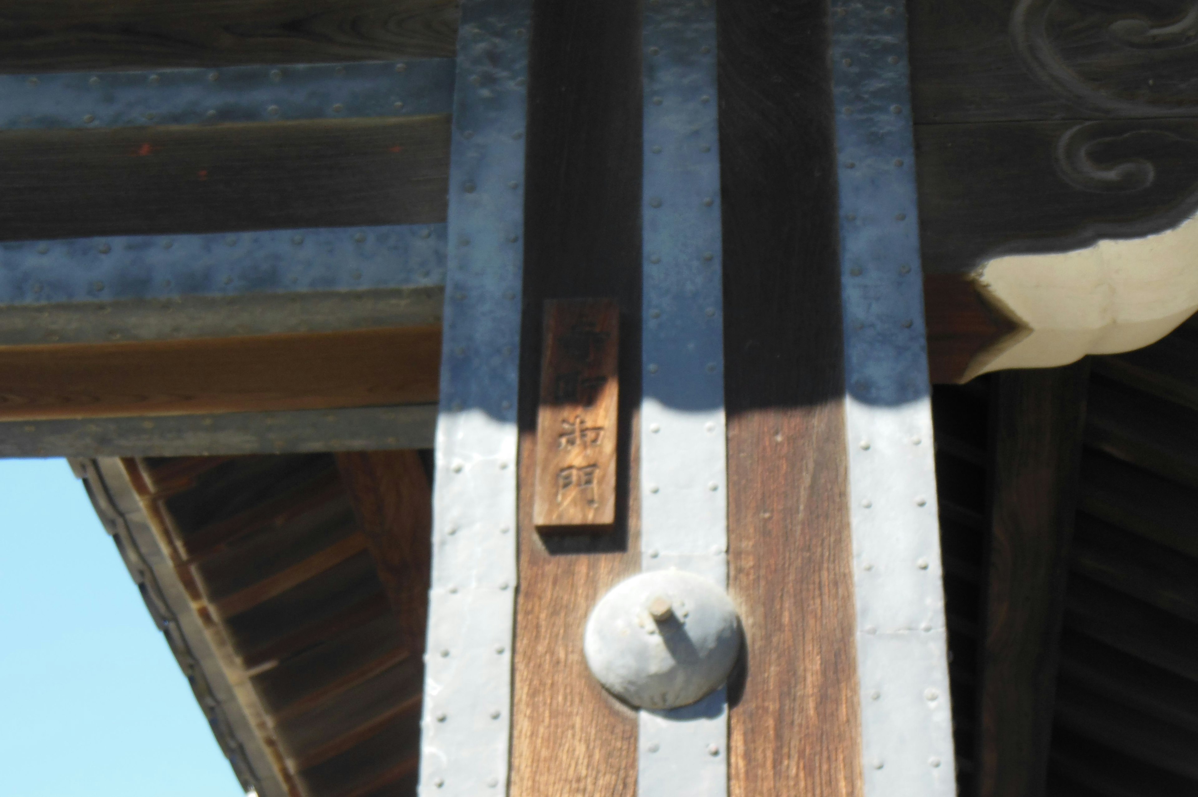 Traditional building detail featuring a wooden post with metal accents