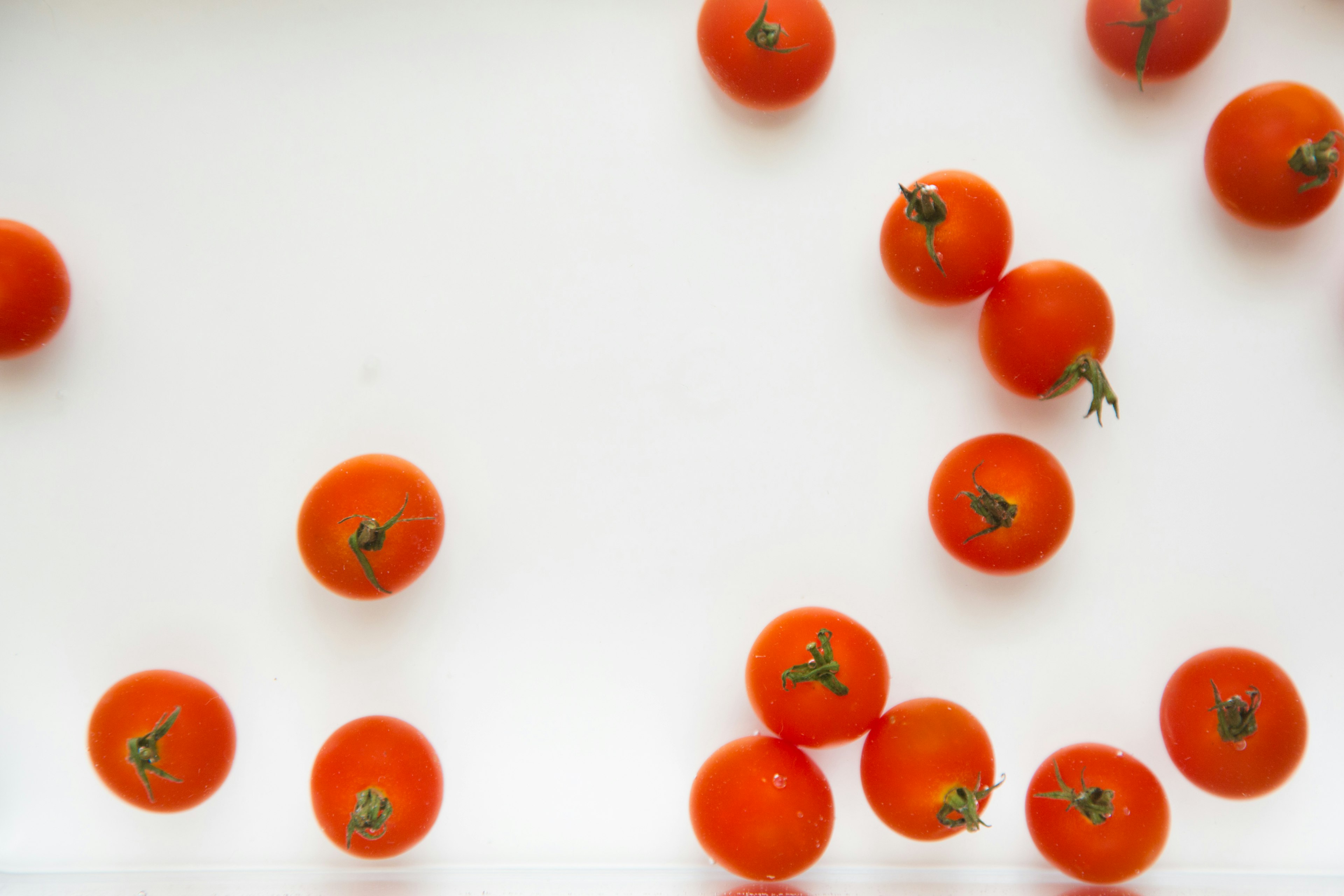 Piccole pomodori arancioni sparsi su un piatto bianco