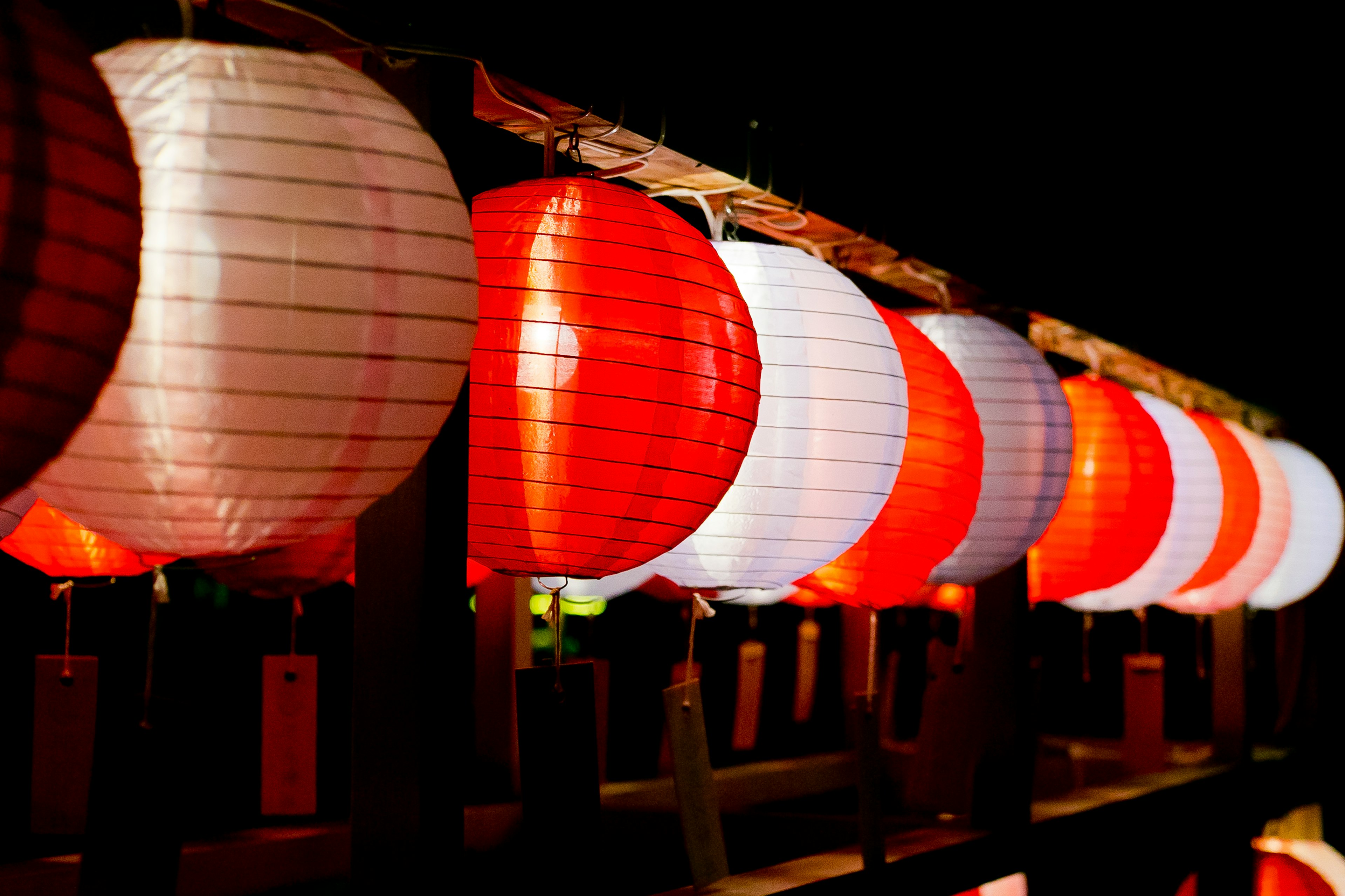 夜の赤と白の提灯が並んでいる風景