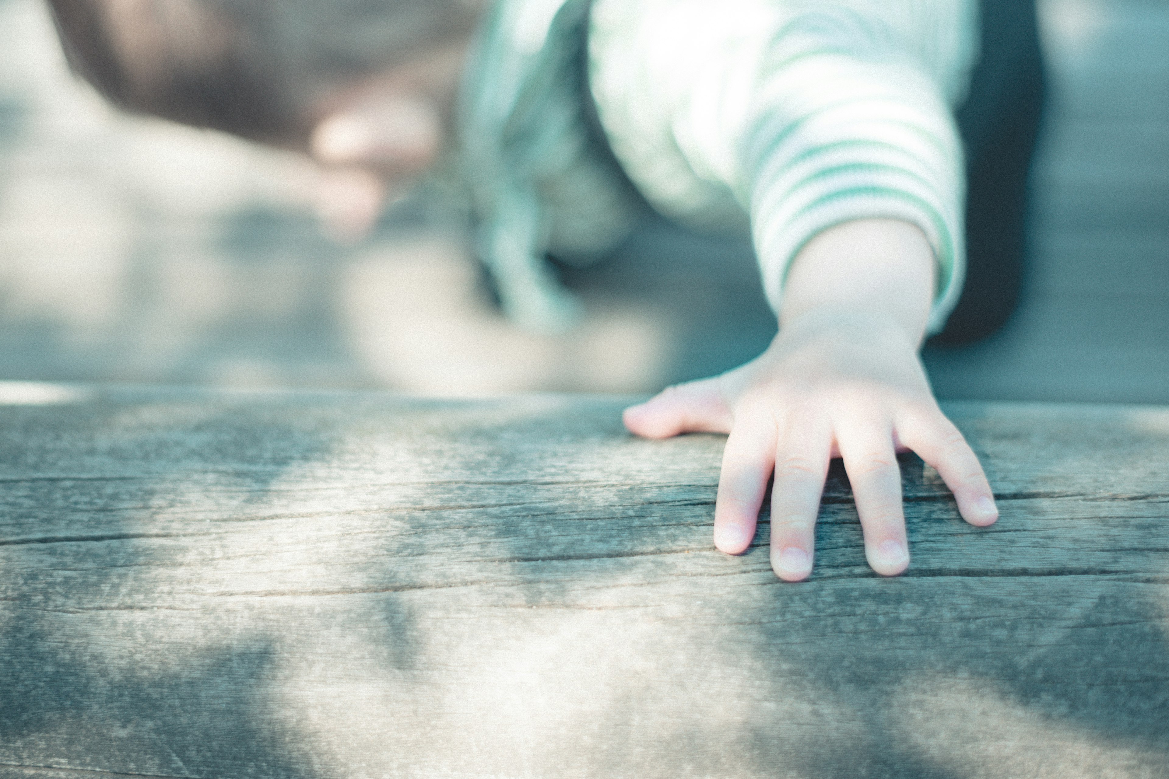 Primo piano della mano di un bambino che tocca una superficie di legno