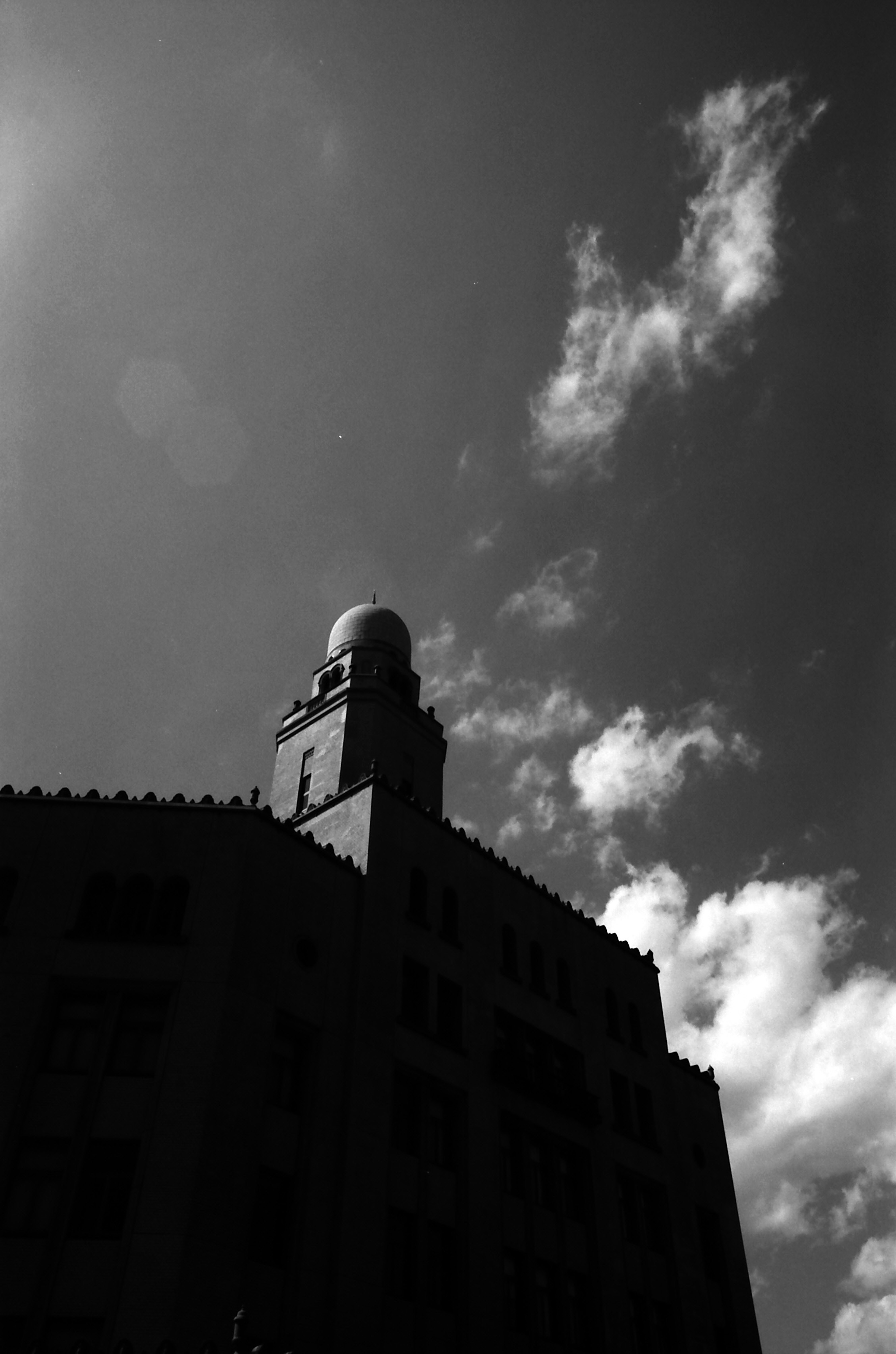 Silueta de un edificio alto contra un cielo nublado en blanco y negro