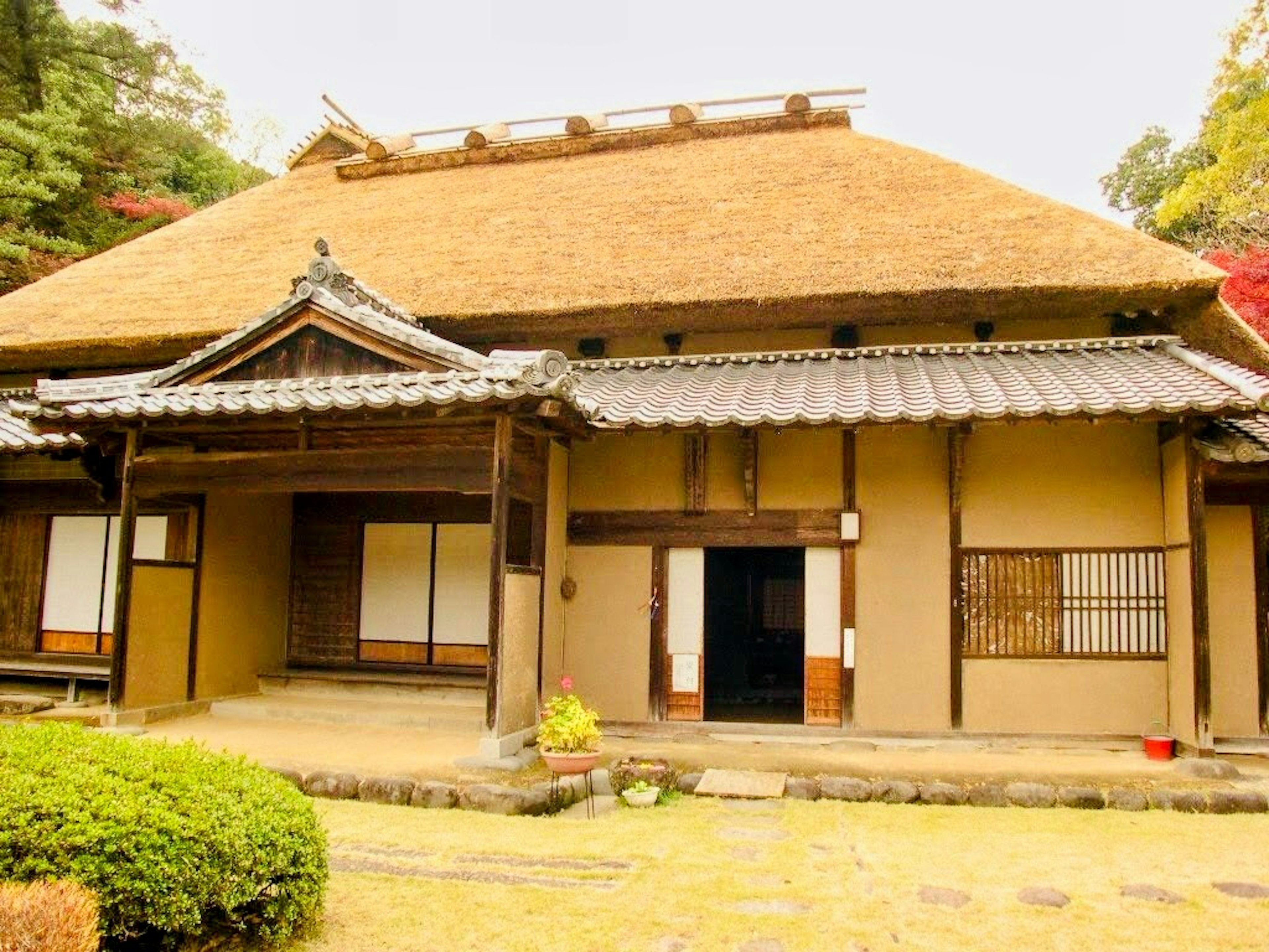 Traditional Japanese house featuring thatched roof and wooden structure