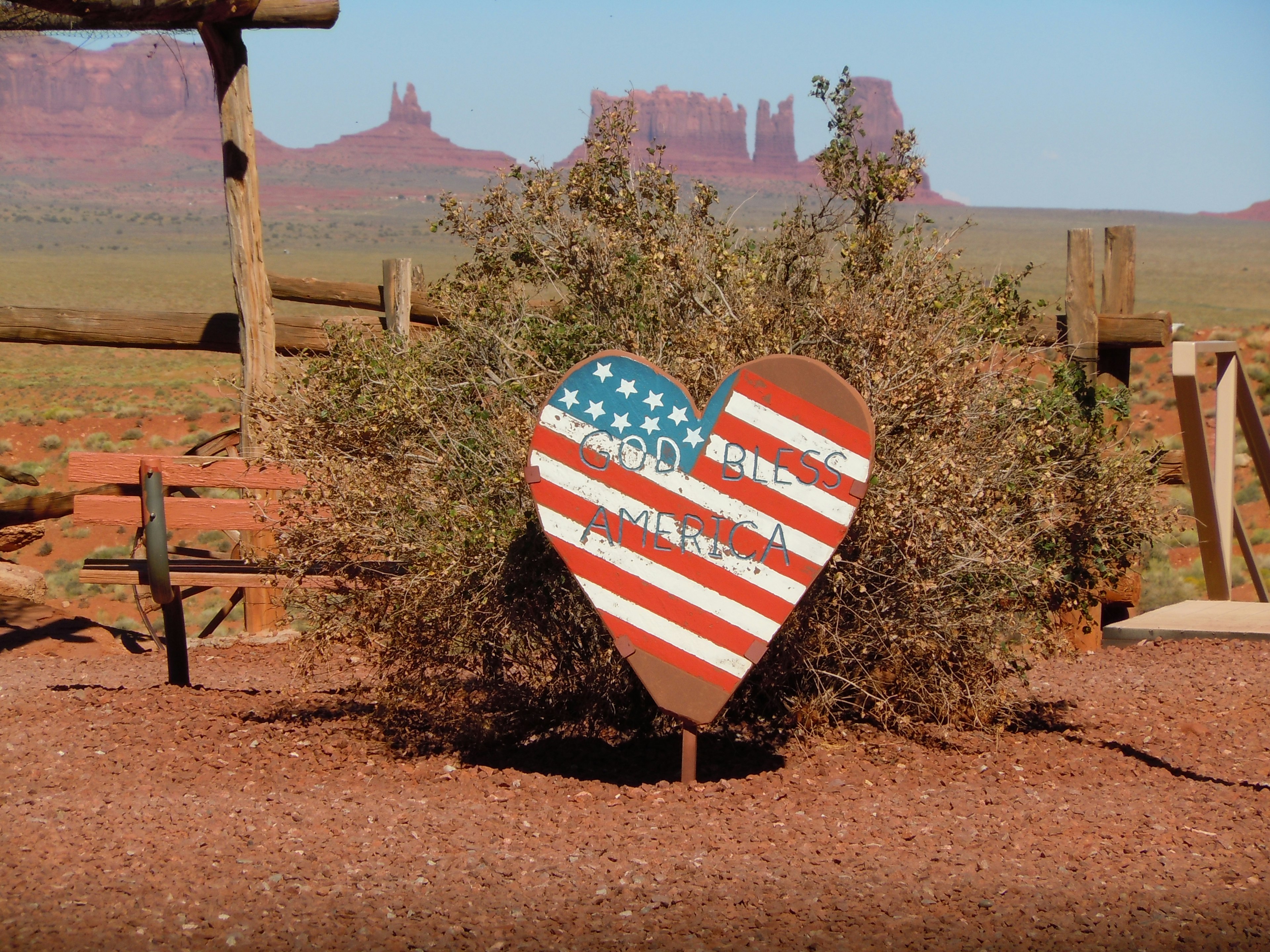 アメリカの国旗が描かれたハート型のサインとモニュメントバレーの風景