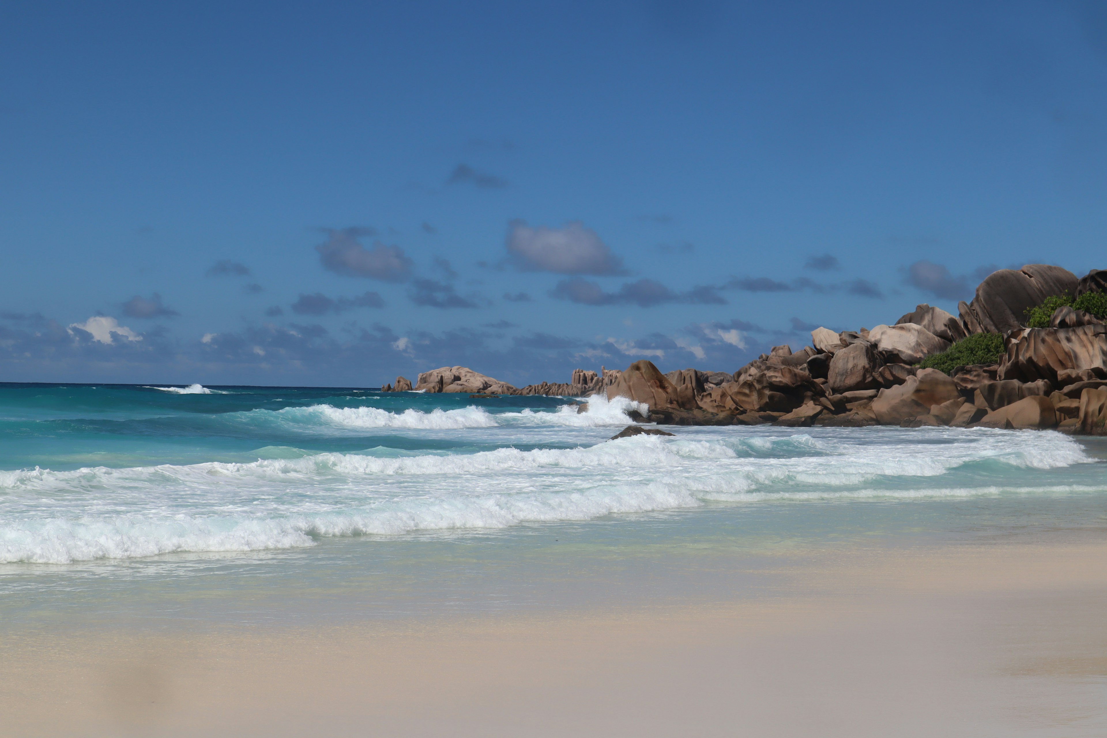 Vista di una spiaggia panoramica con oceano blu e sabbia bianca