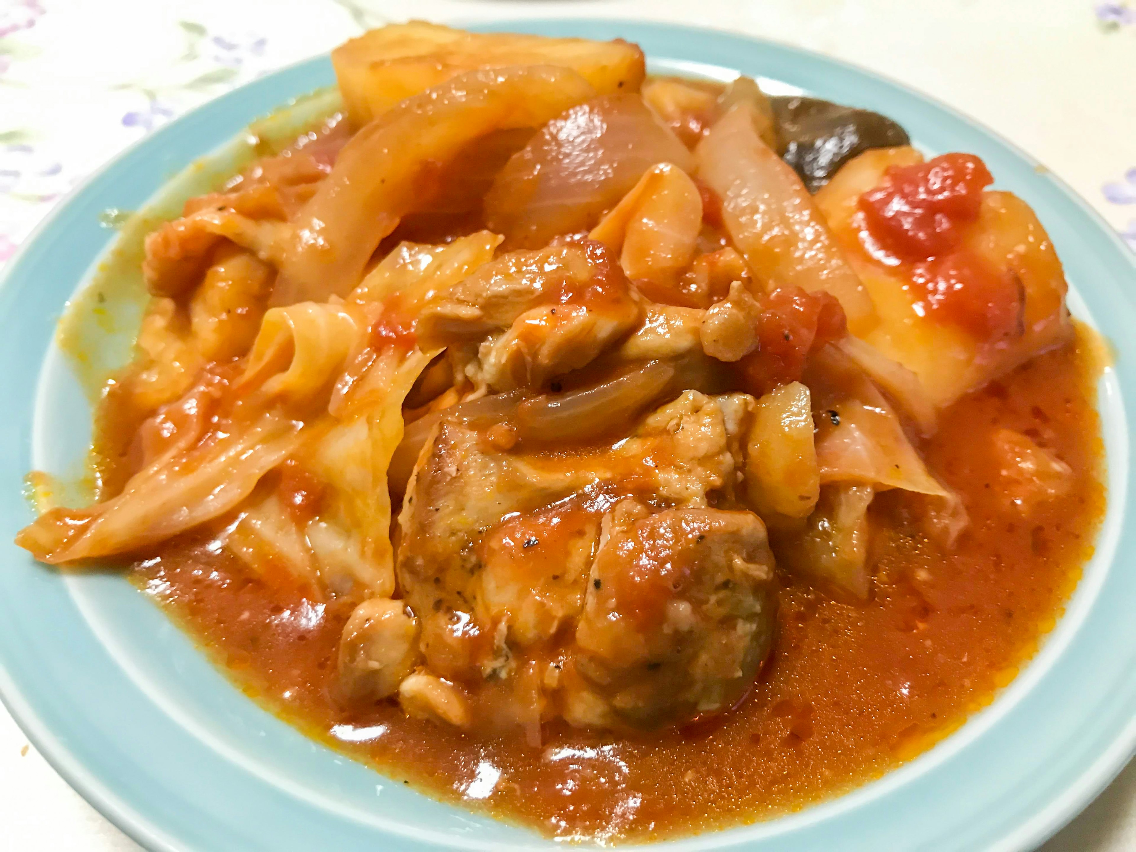 Plate of chicken and vegetables in red sauce