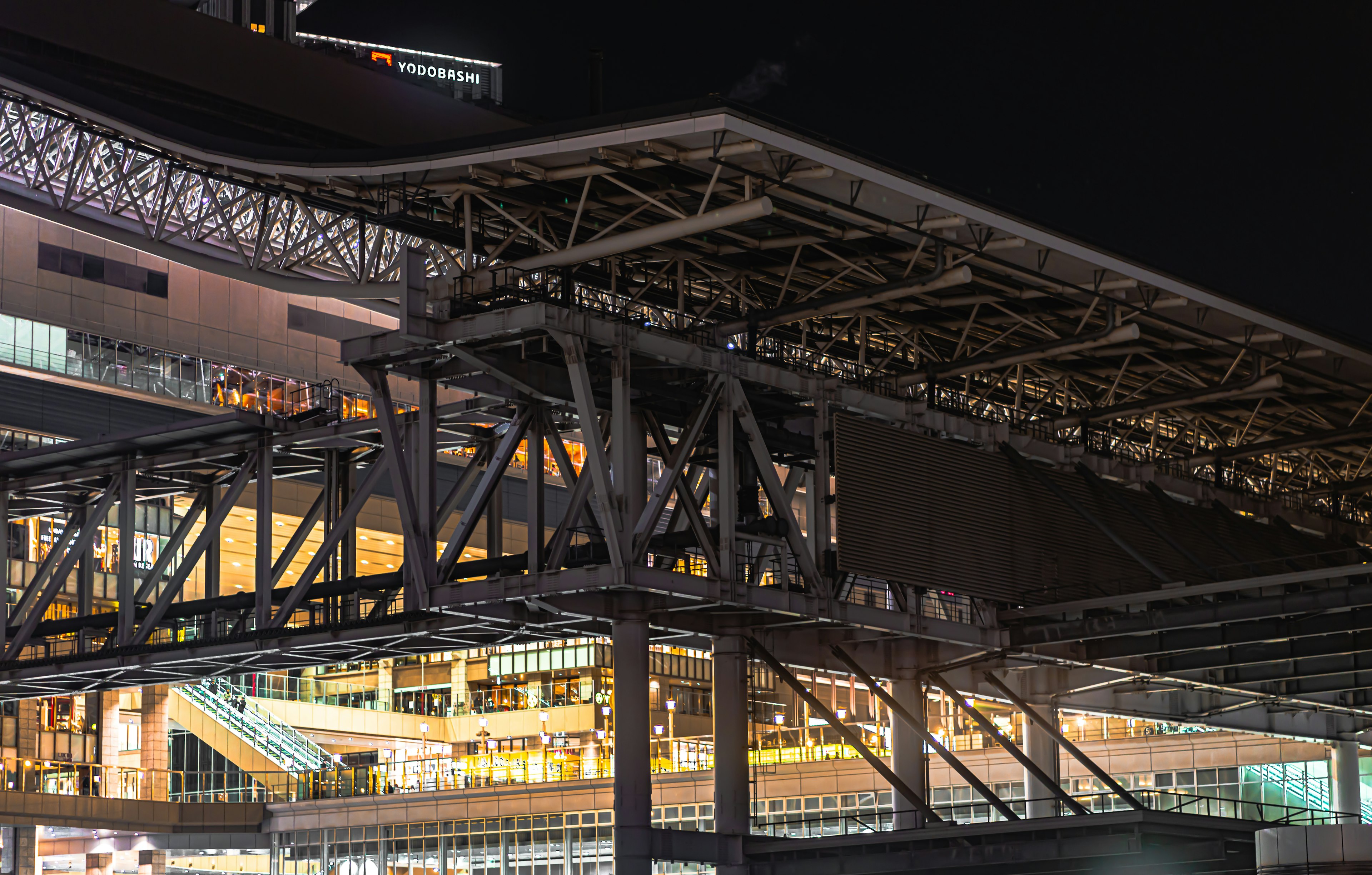 Vue nocturne d'une structure de bâtiment avec des intérieurs illuminés