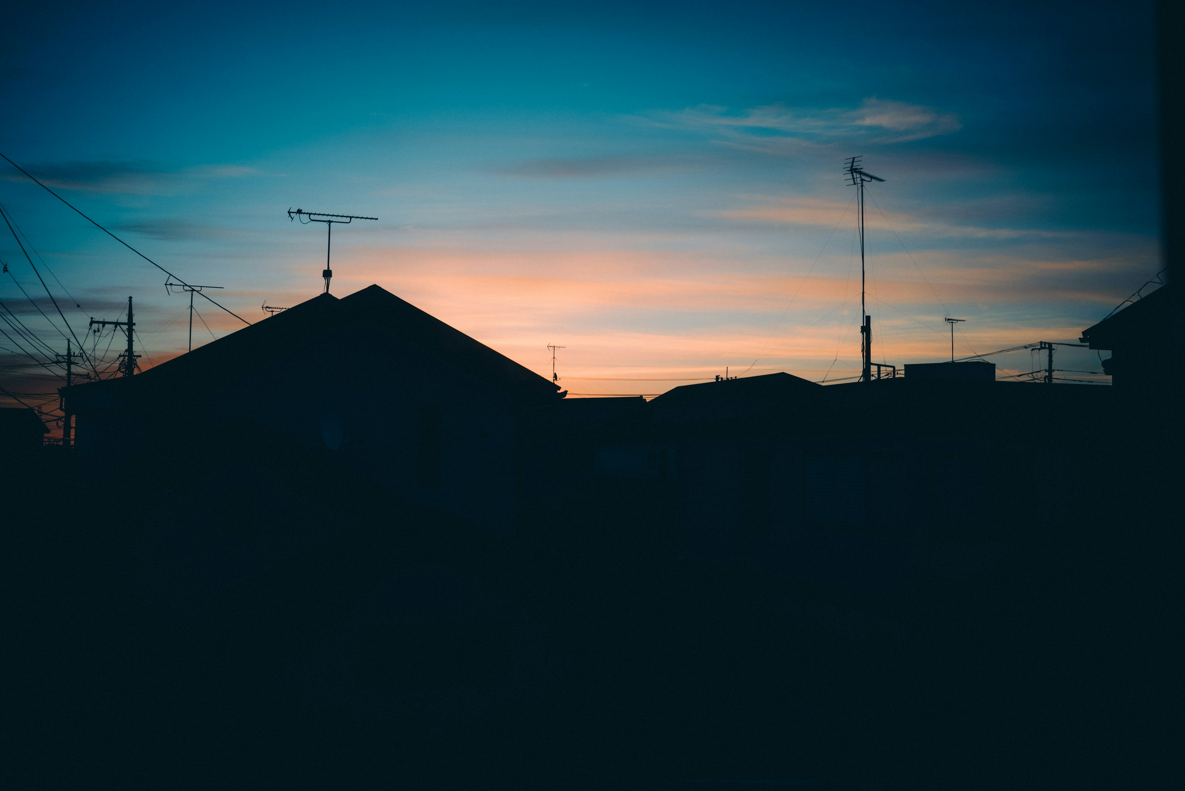 夕暮れの空を背景にしたシルエットの家々