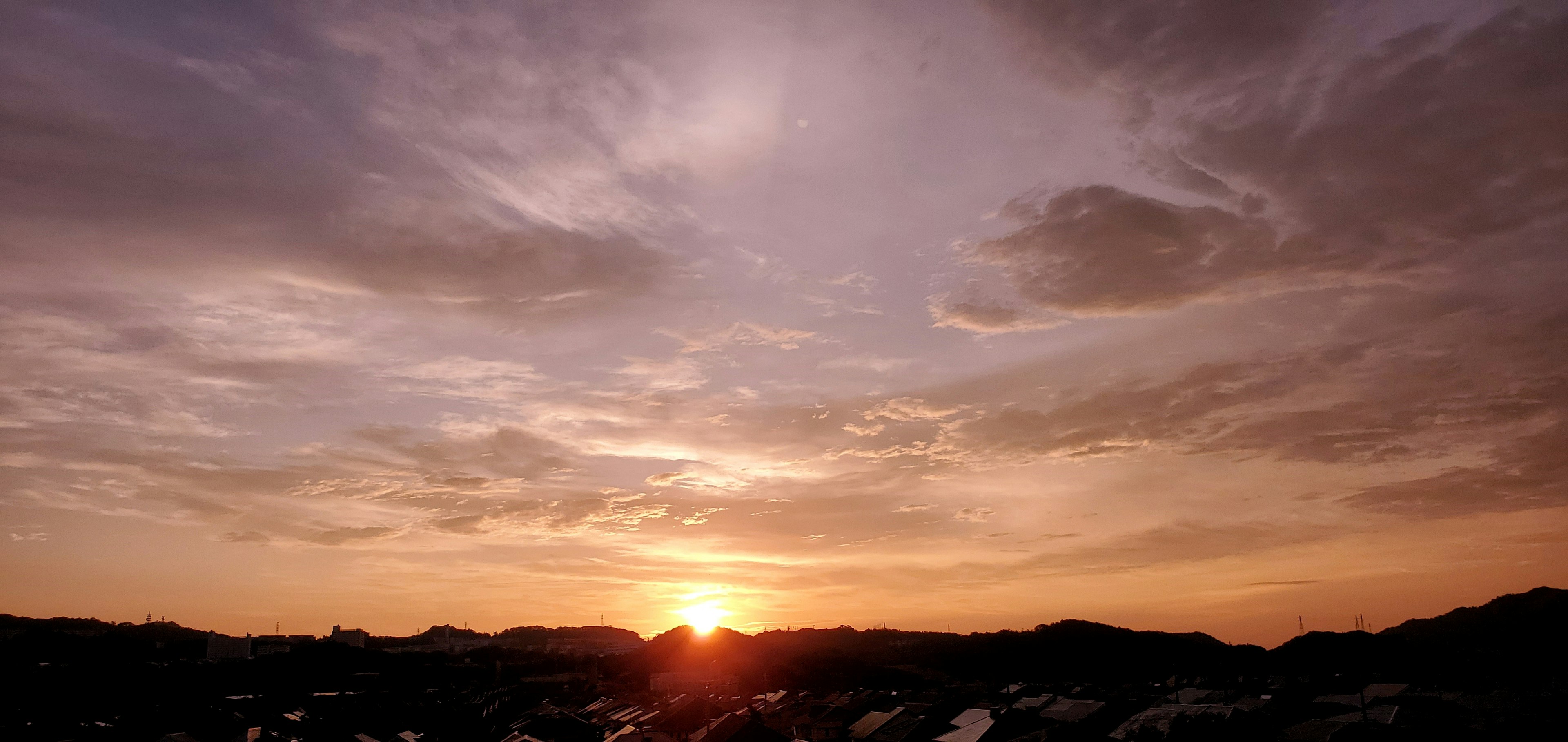 夕日が沈む空の風景に柔らかな雲が広がる