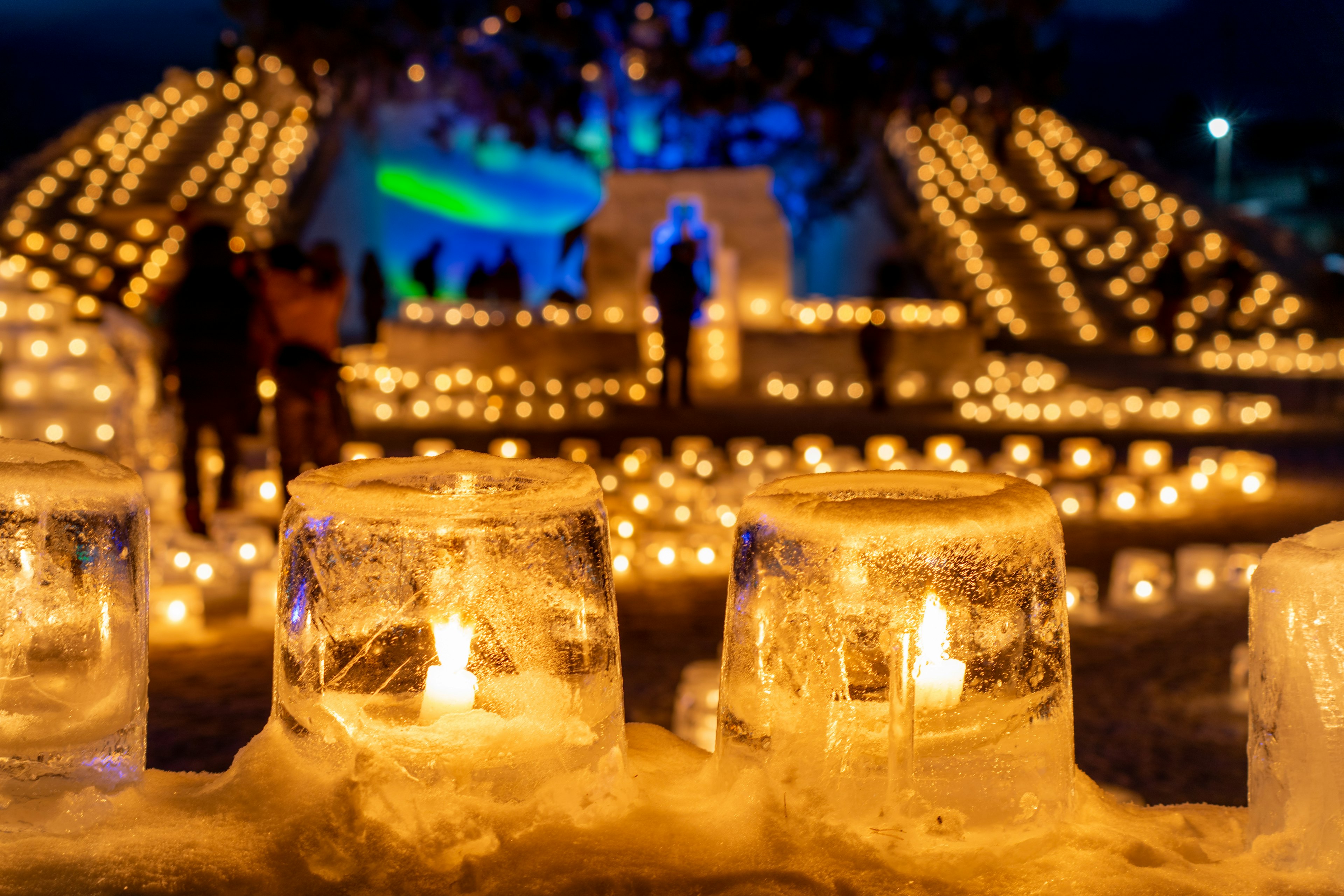 Belle scène d'un festival de bougies nocturne avec des bougies en glace et des lumières chaudes créant une atmosphère magique