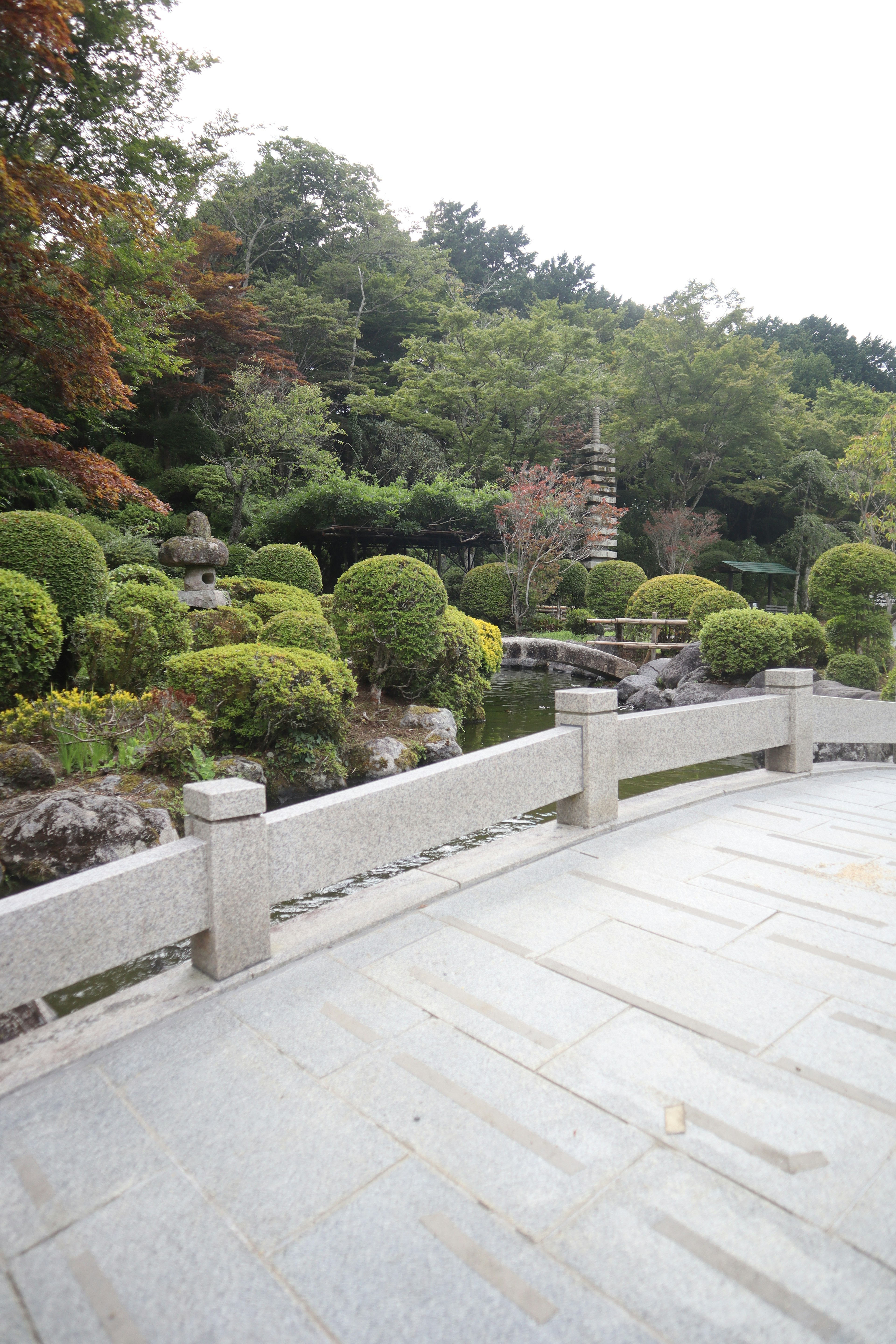 美しい日本庭園の風景 石の手すりがある静かな場所 植物や木々が緑にあふれた景色