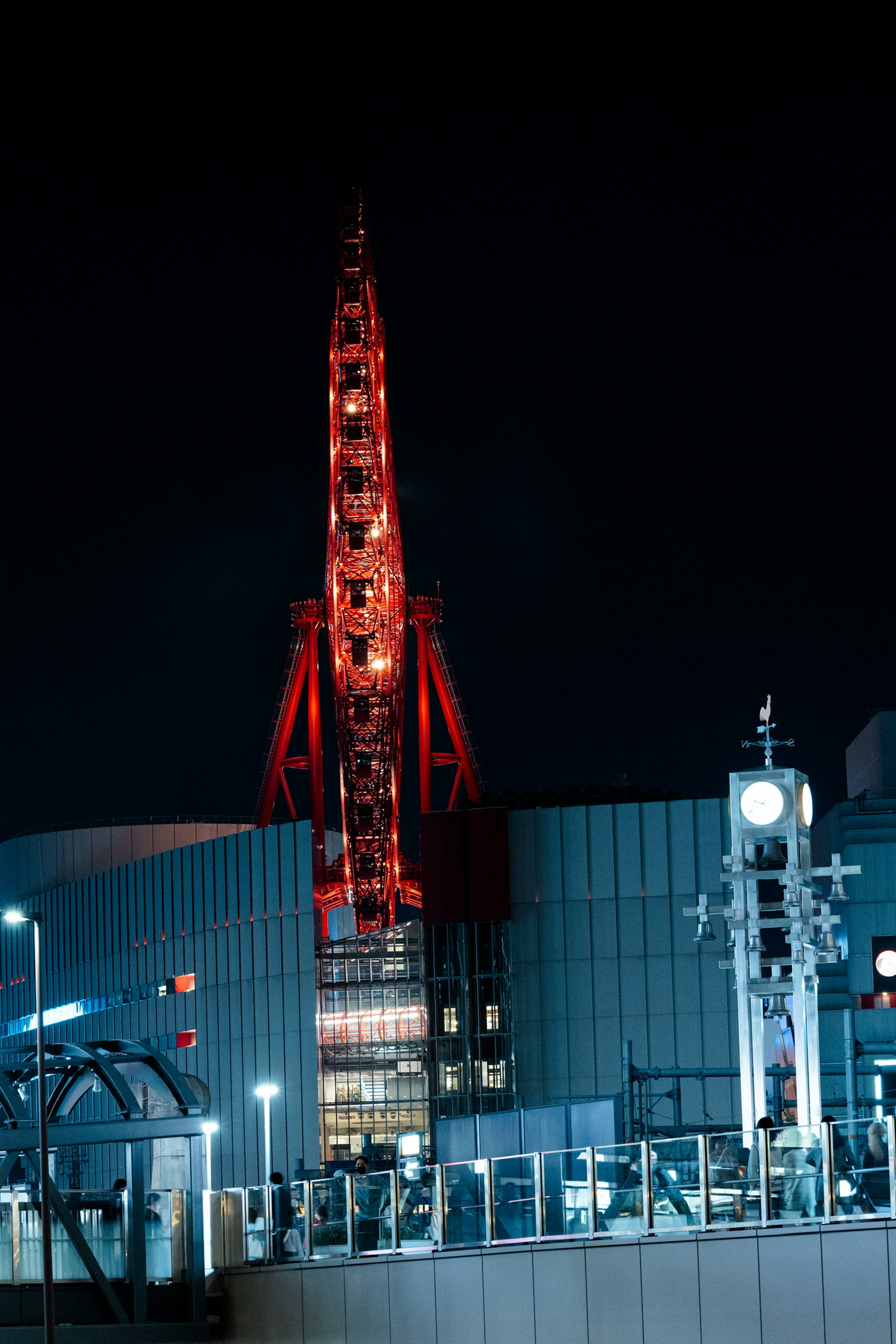 Tour de Tokyo illuminée en rouge la nuit avec des bâtiments environnants