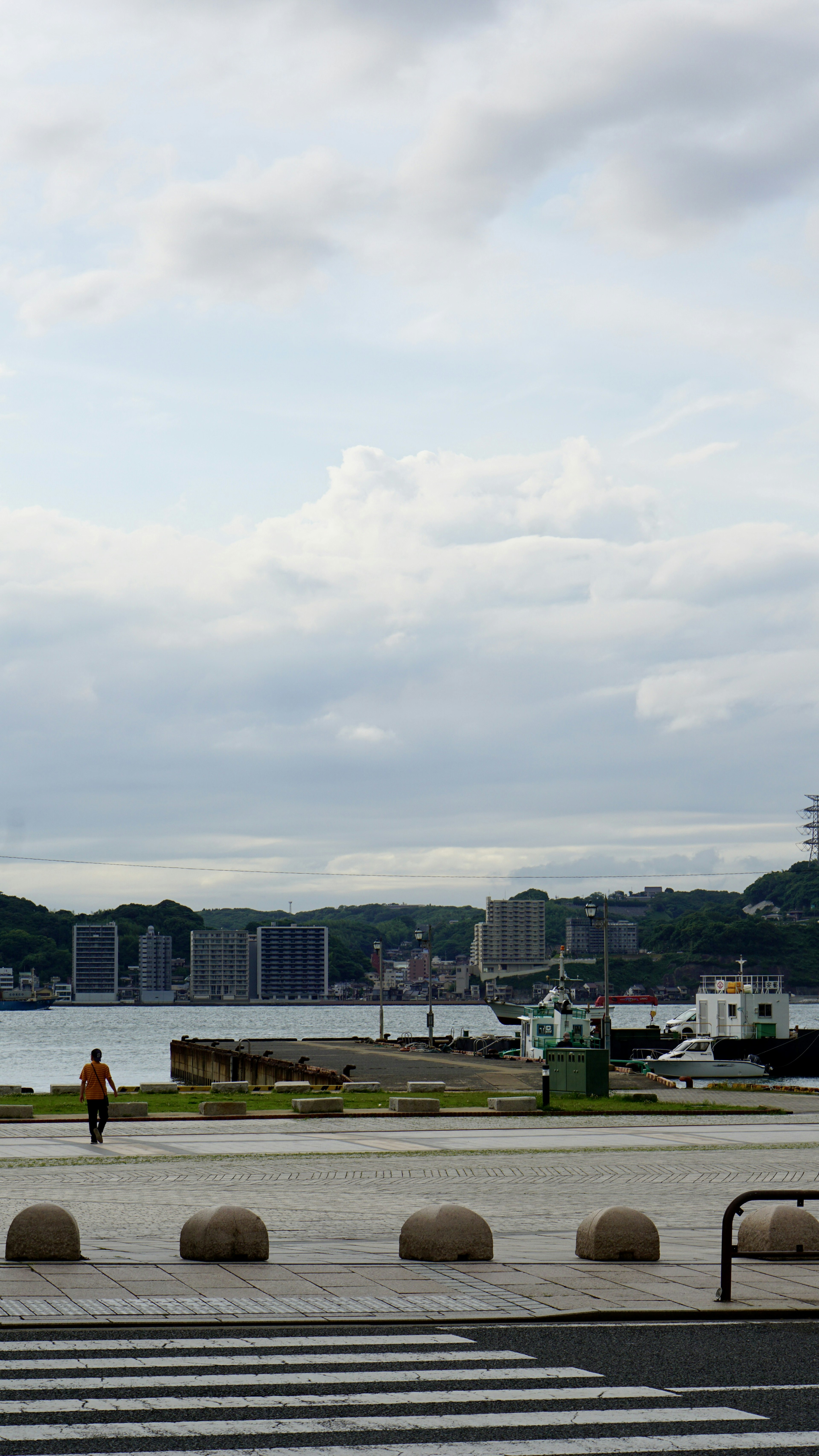 Coastal view of a harbor town with a person standing by the water