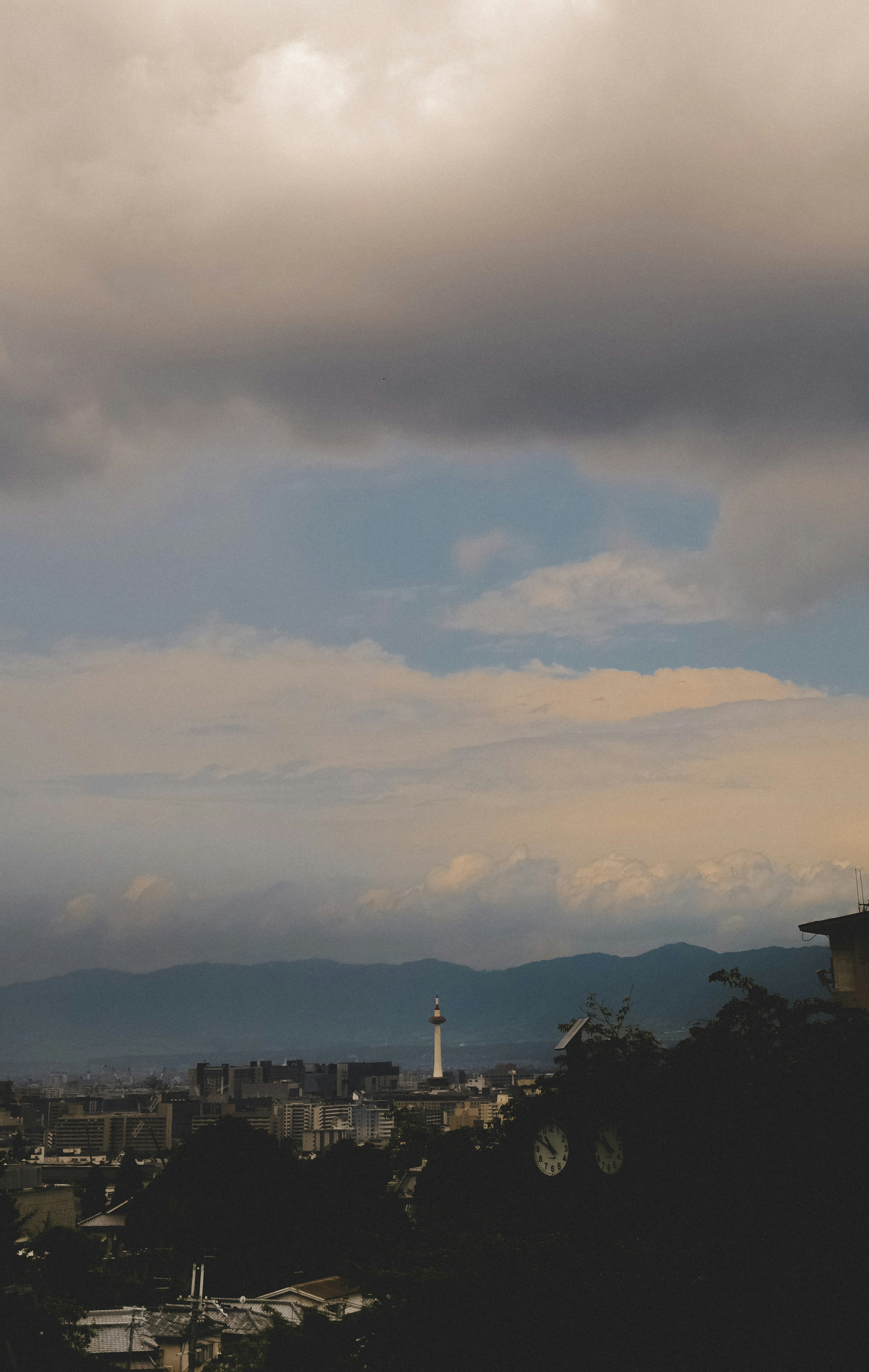 Paisaje urbano bajo un cielo nublado con montañas distantes