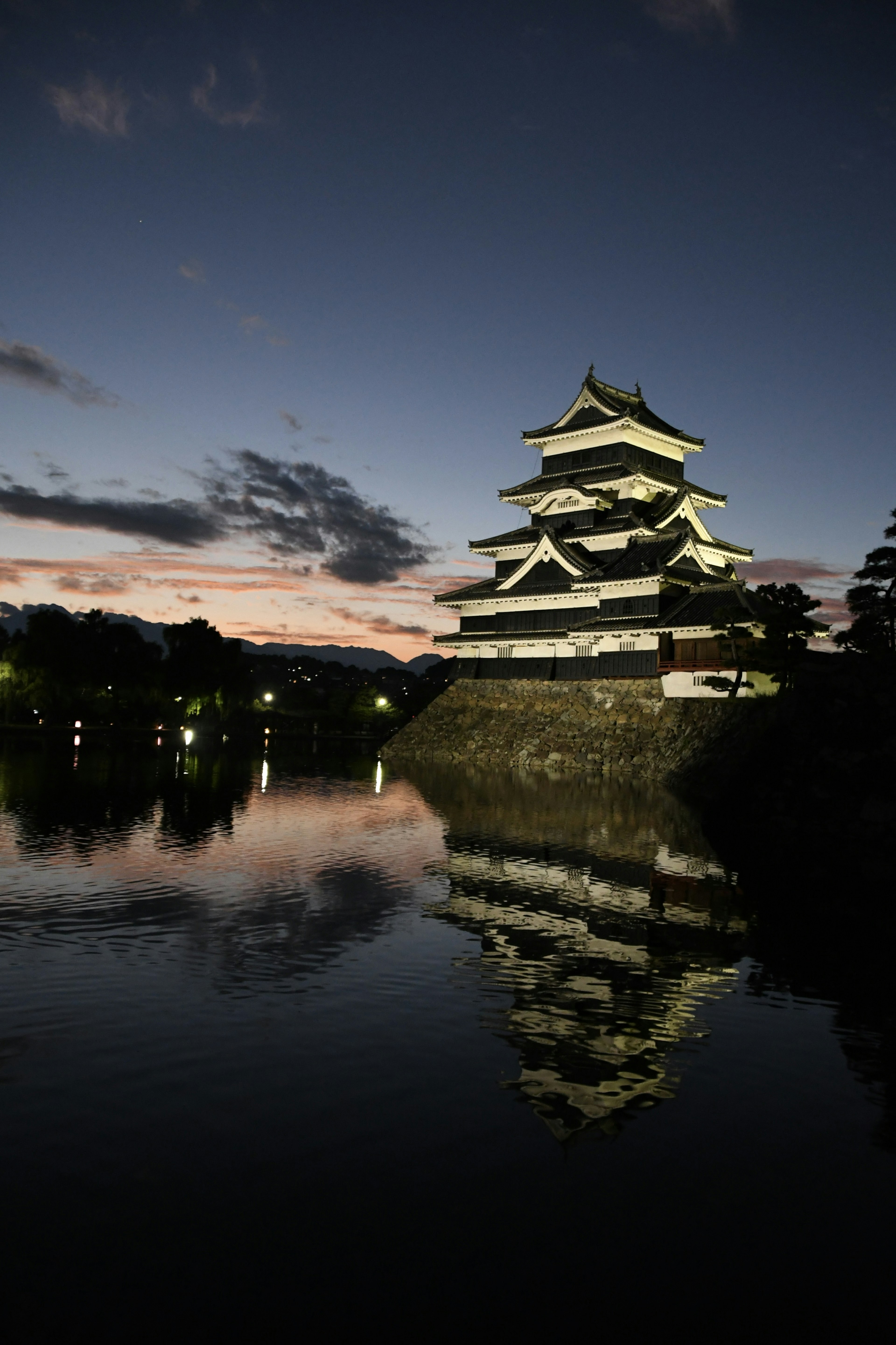 Pemandangan malam Kastil Matsumoto dengan refleksi di air