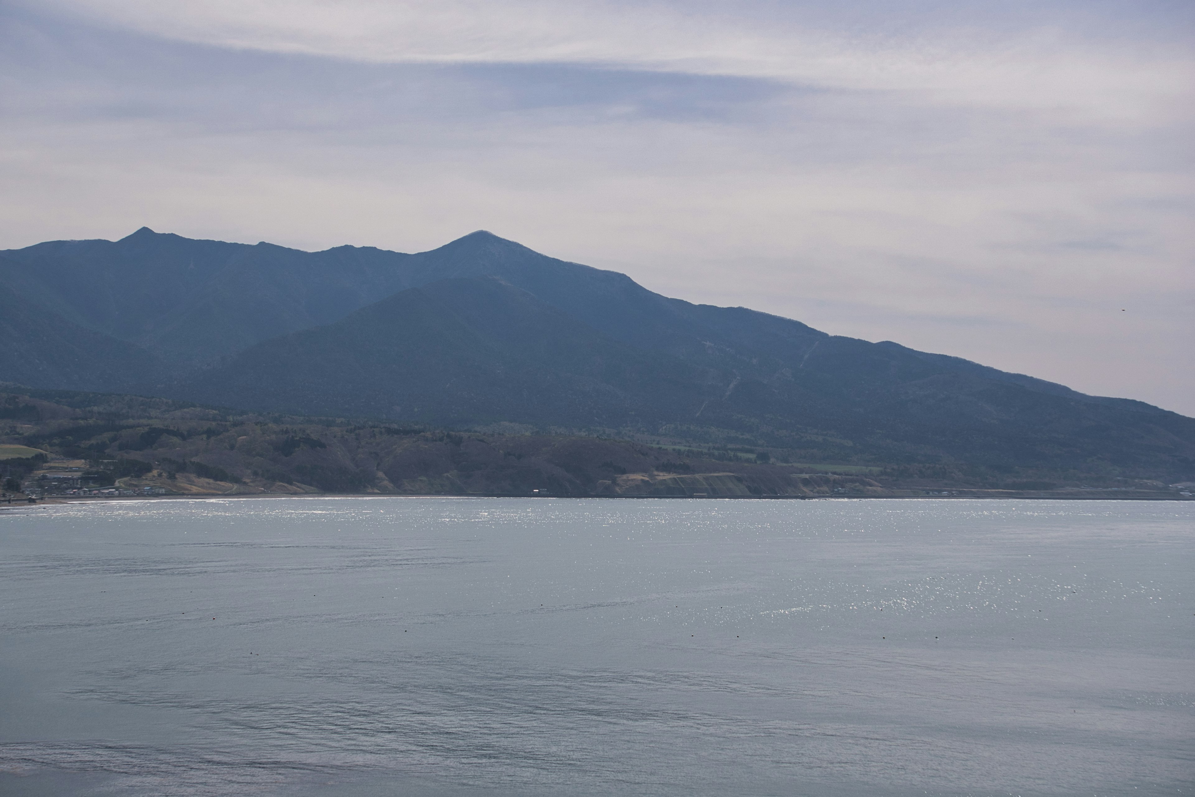 Mare calmo con montagne blu sullo sfondo