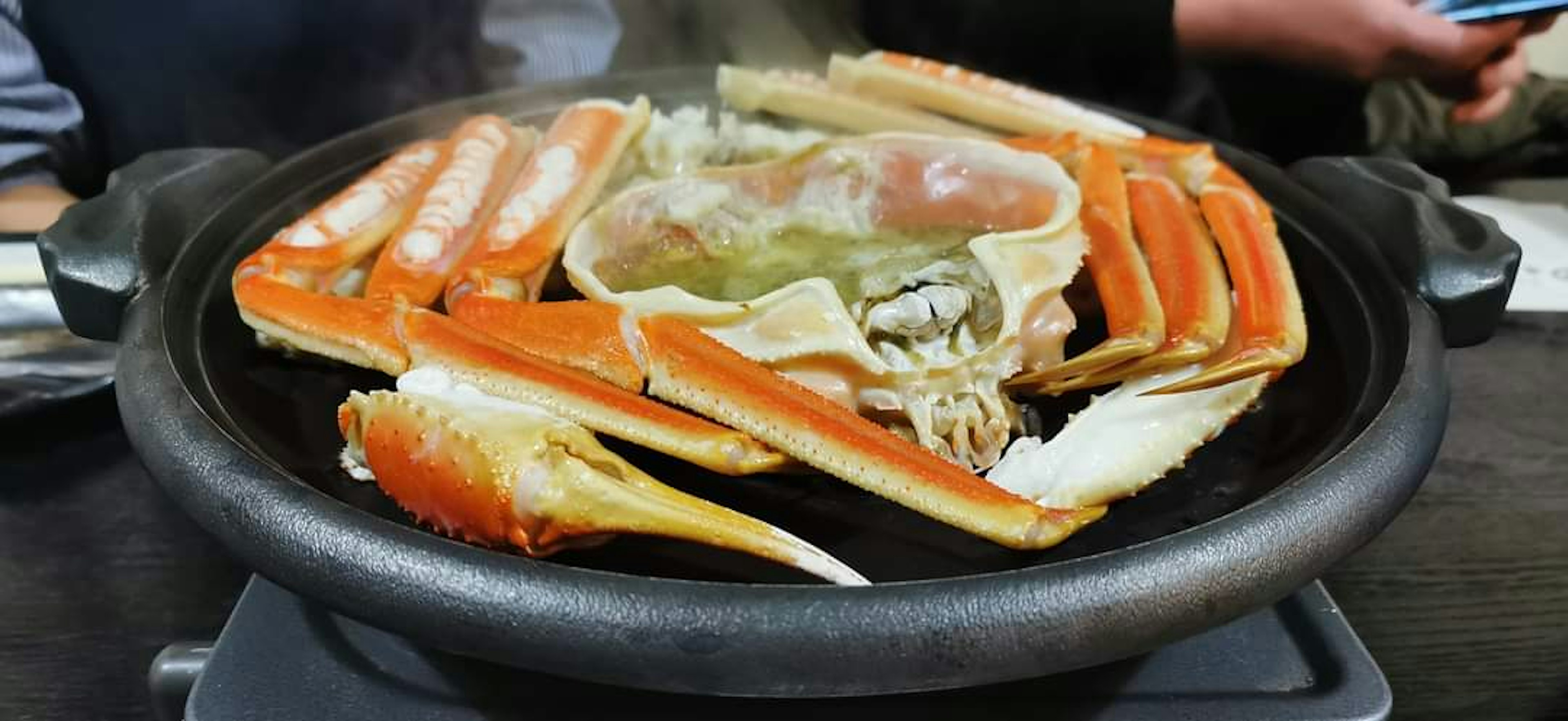 Kepiting kukus dan makanan laut segar disusun di atas panci panas