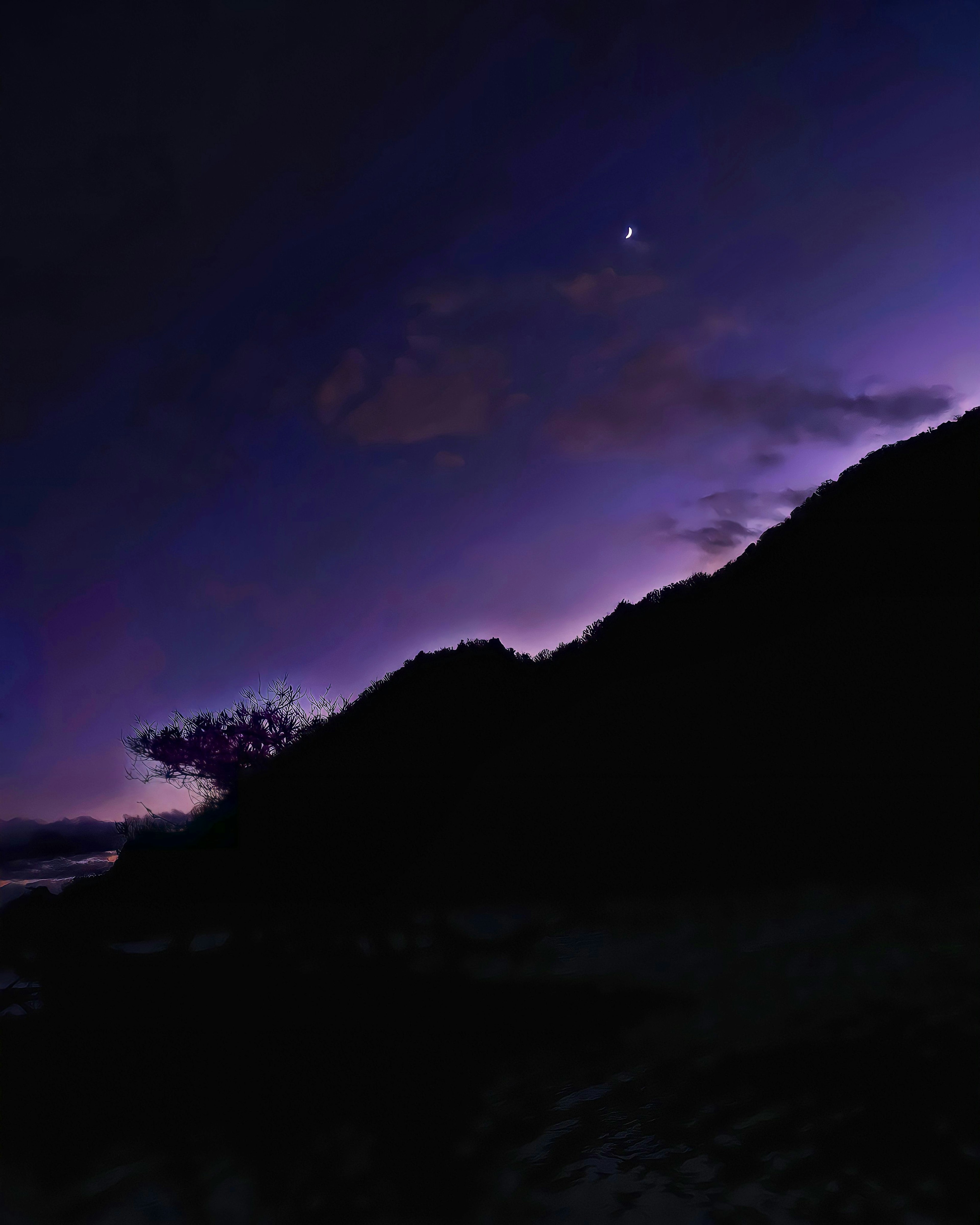 Silhouette of mountains against a purple sky with a star