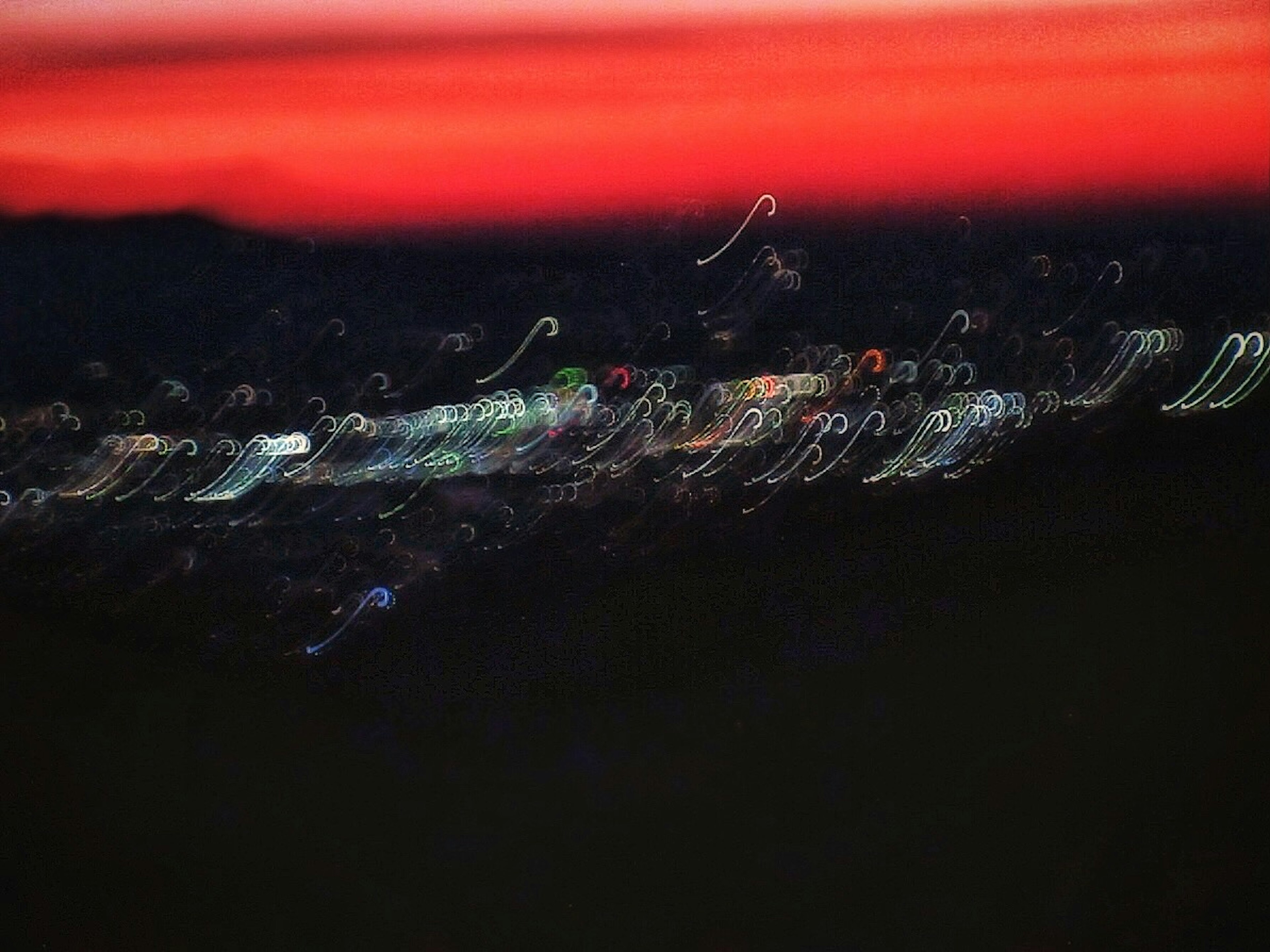 Blurred cityscape at night with a red sunset sky