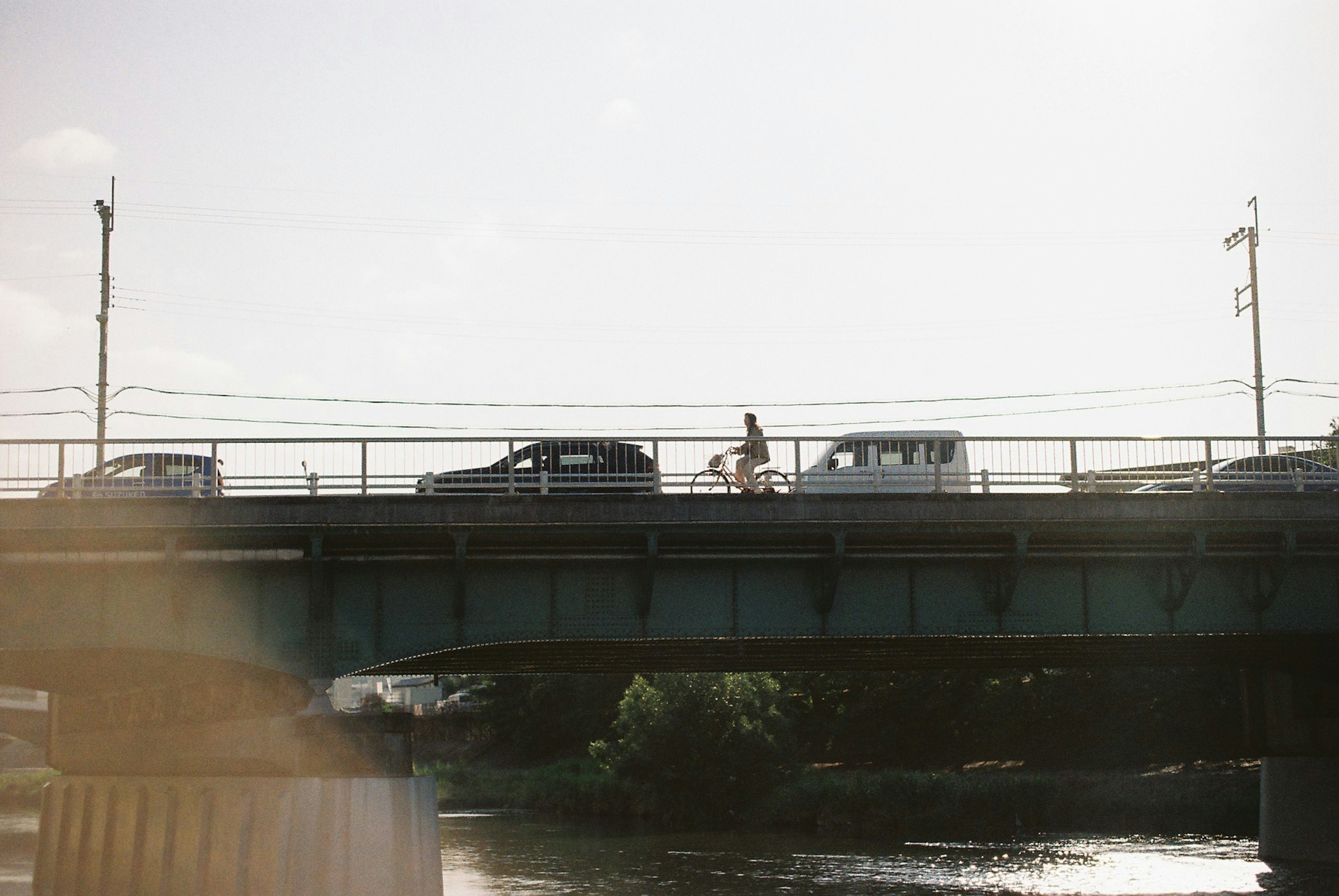 橋の上を走る自転車と車の風景