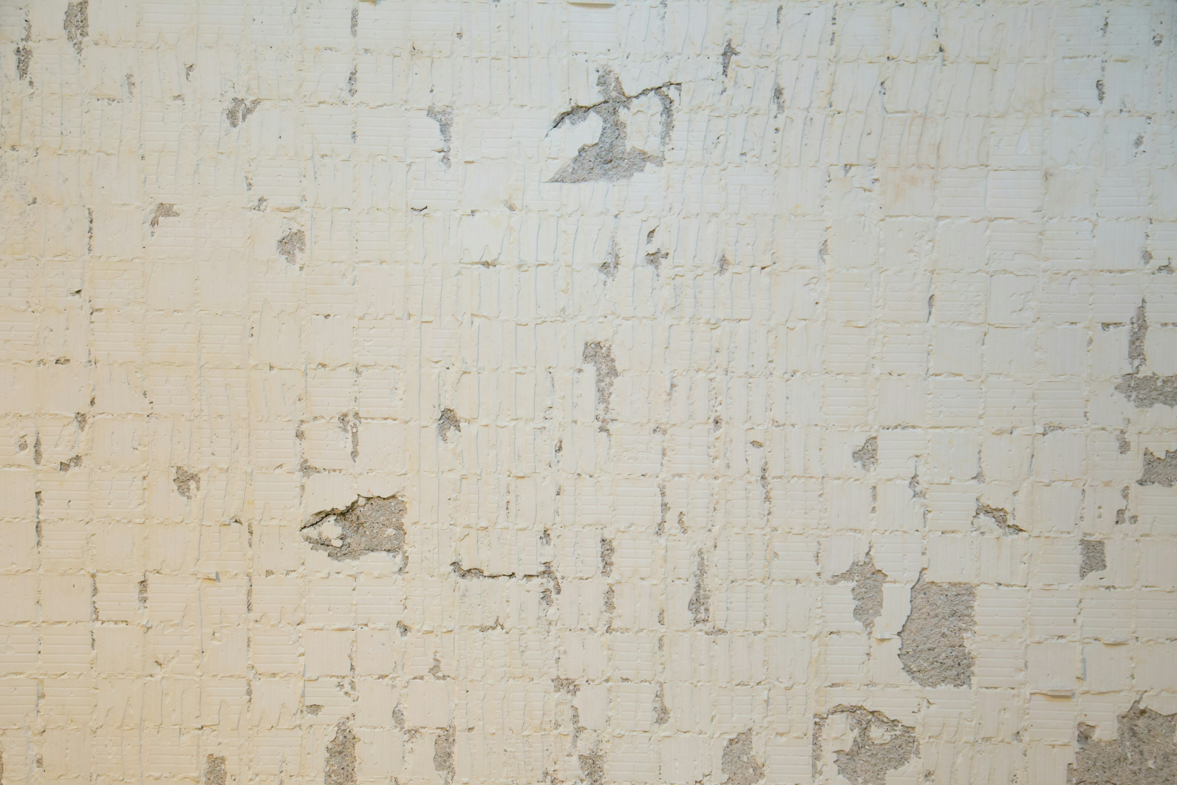 Textured white wall with peeling paint