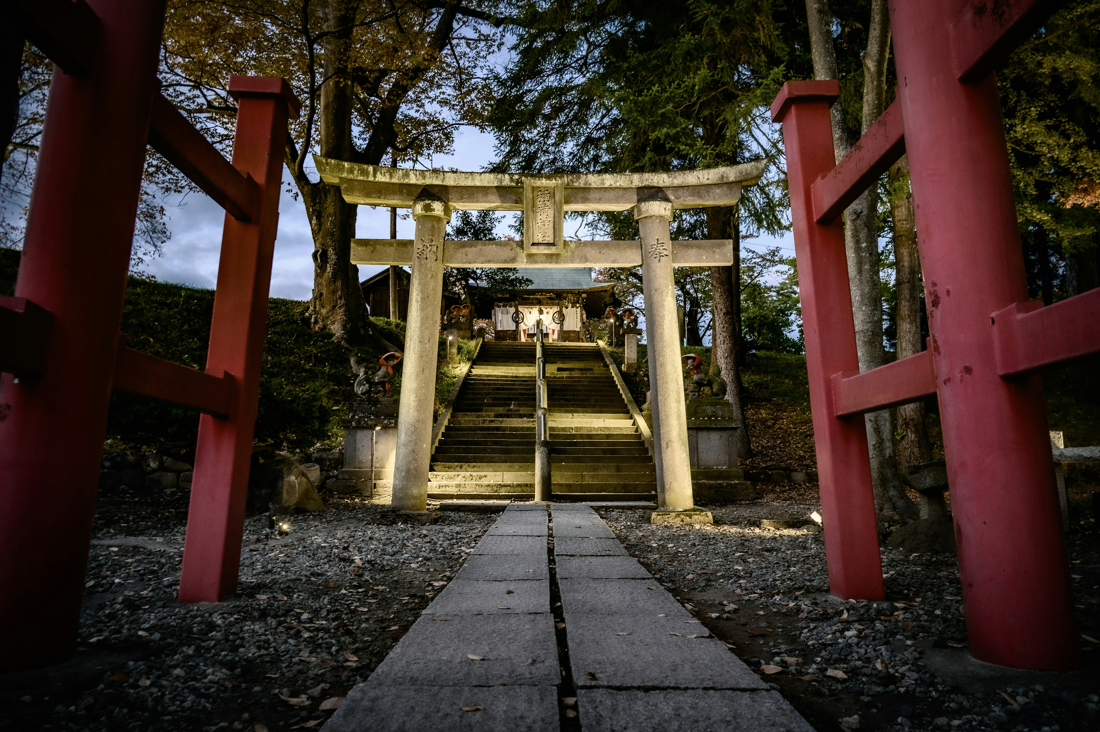 赤い鳥居と石の階段がある神社の入口の夜景