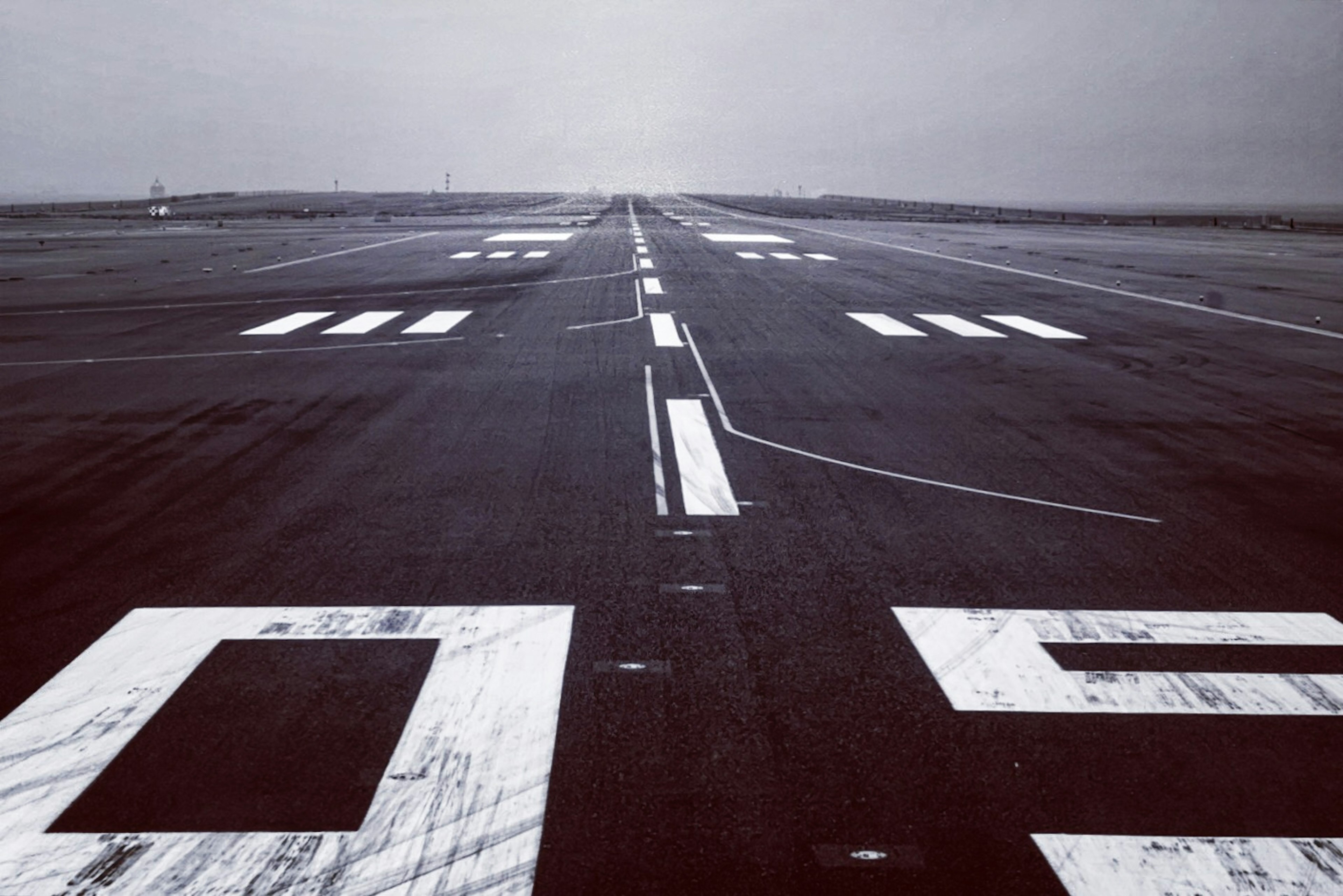 Runway with white markings and a gray background