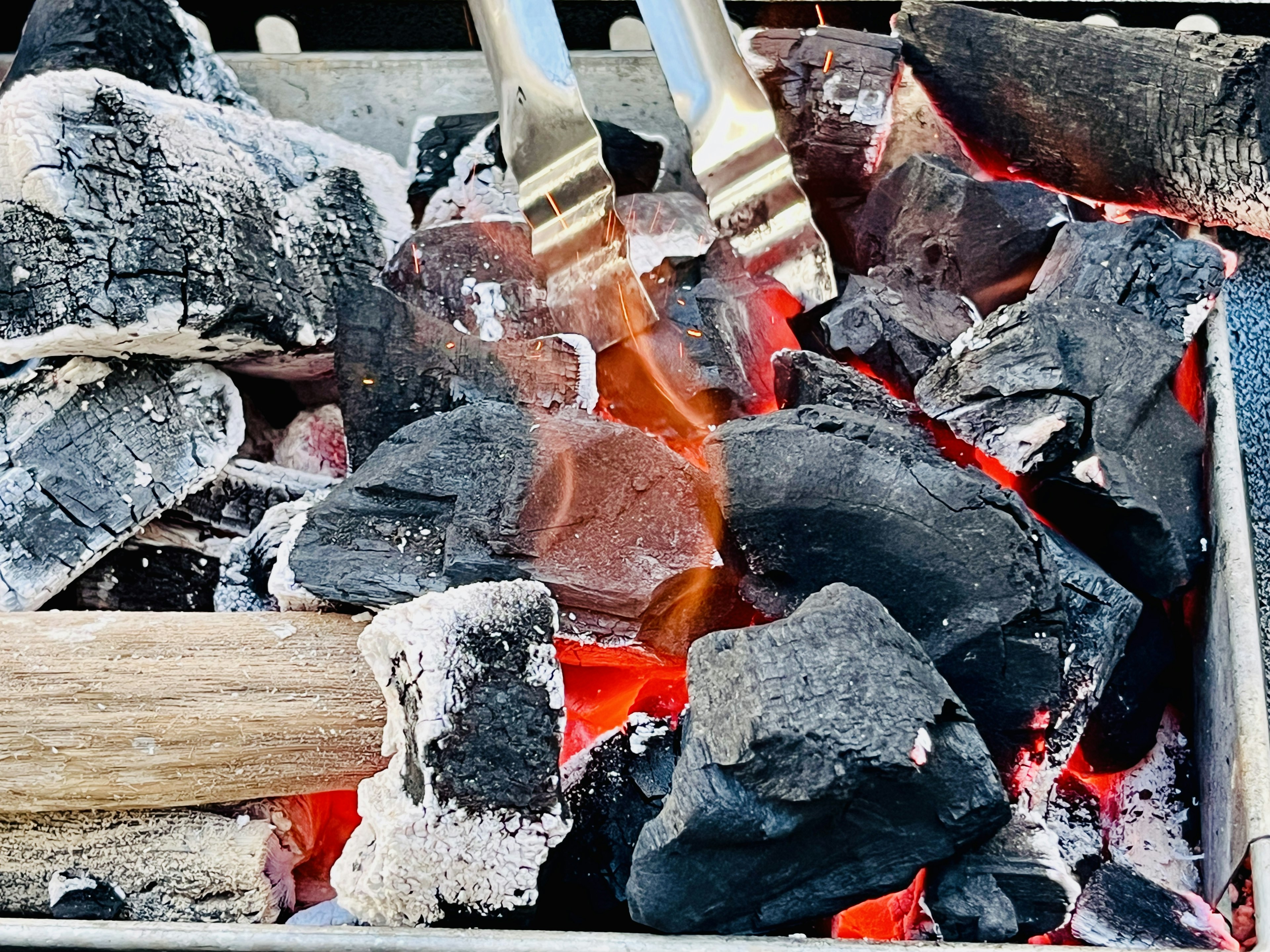 炭火焼きのための炭とトングのクローズアップ