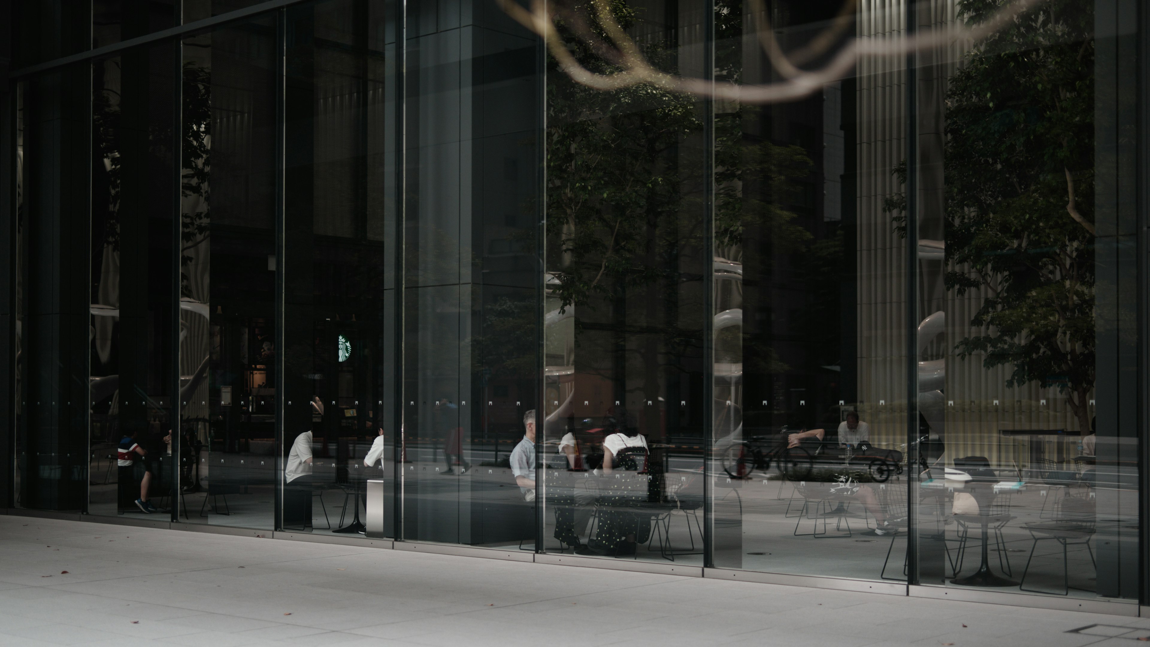 Façade en verre moderne avec des personnes assises à l'intérieur