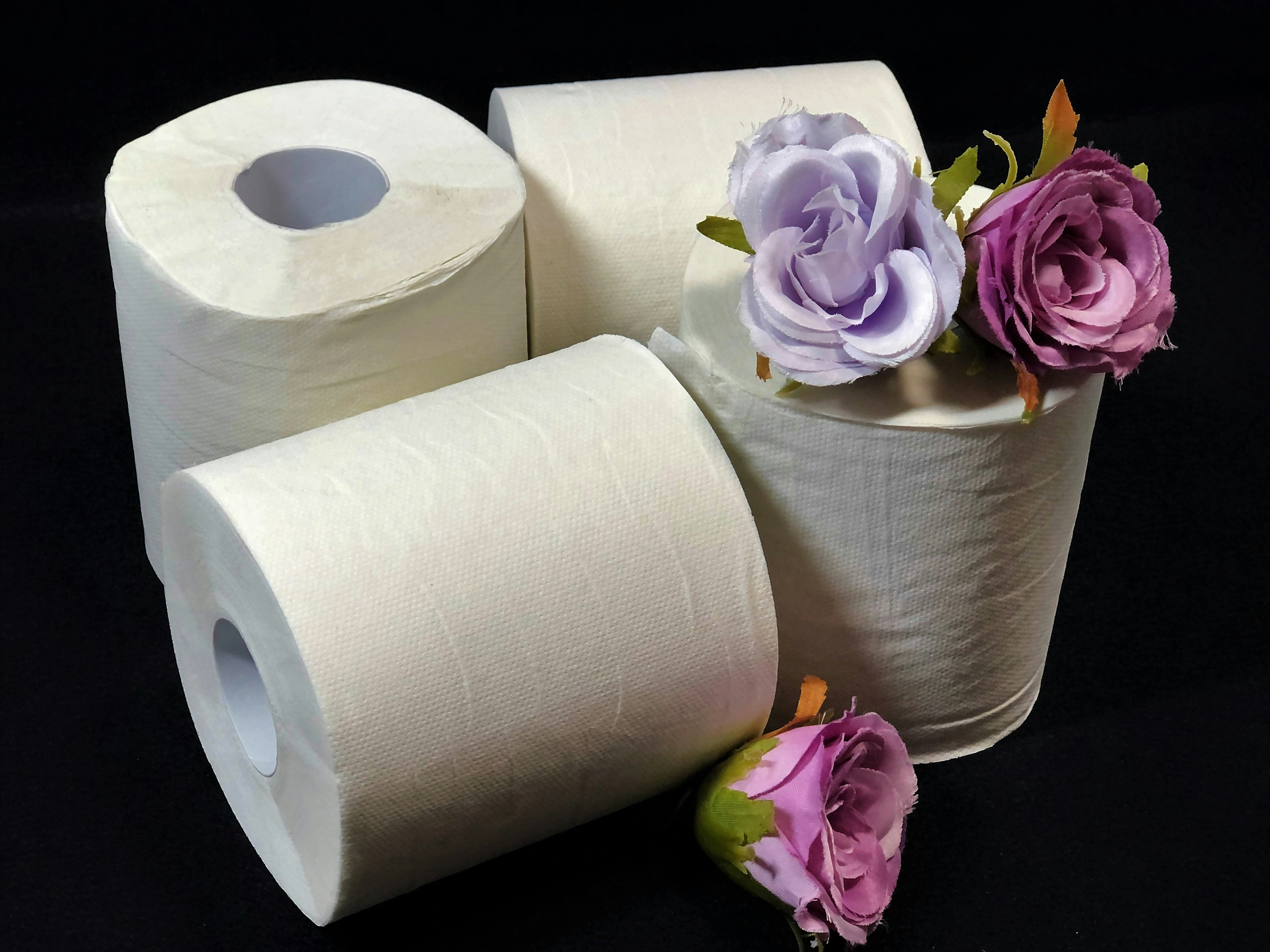 Rollos de papel higiénico con arreglos de flores moradas