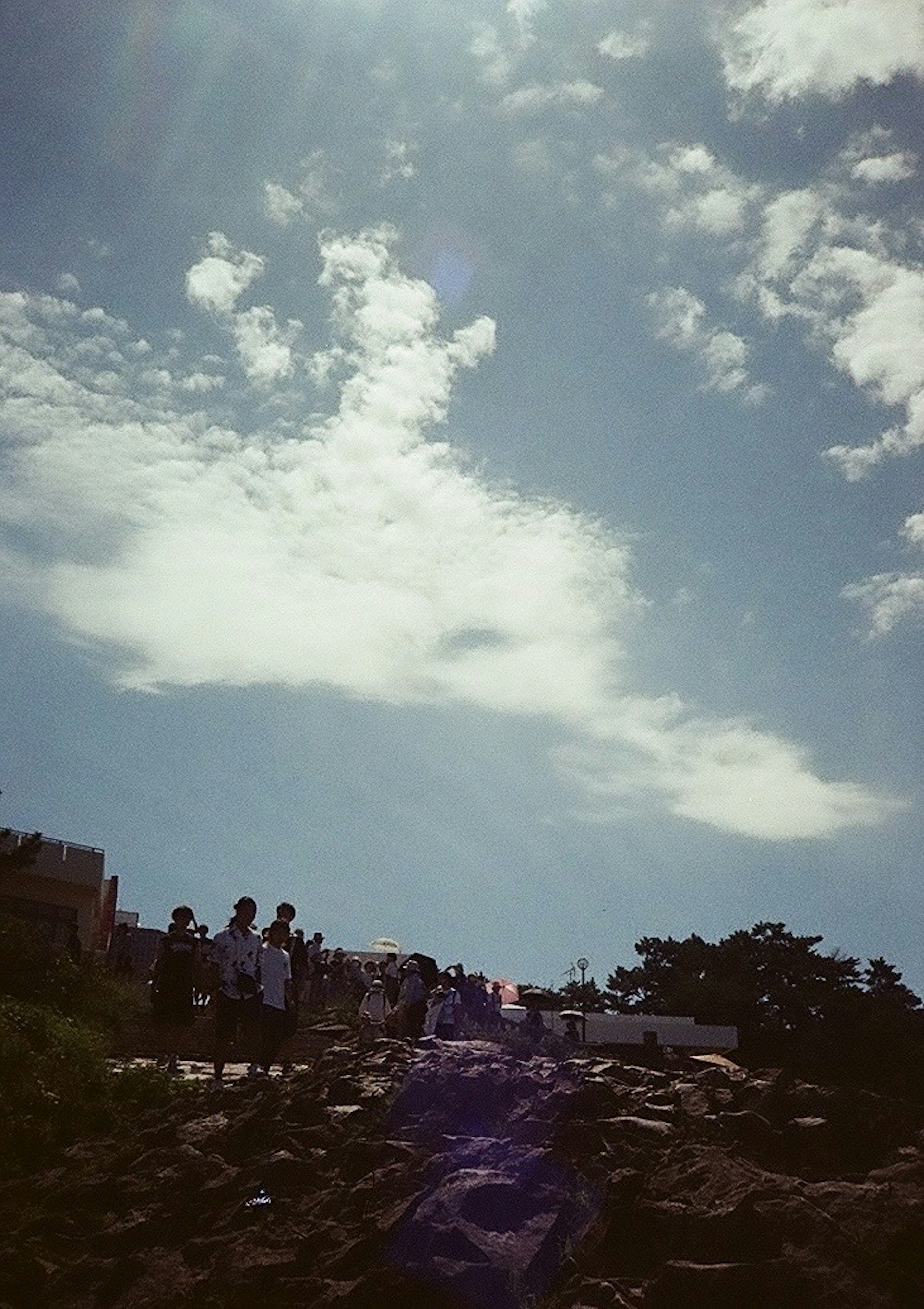 青空と雲の下に人々がいる山の風景