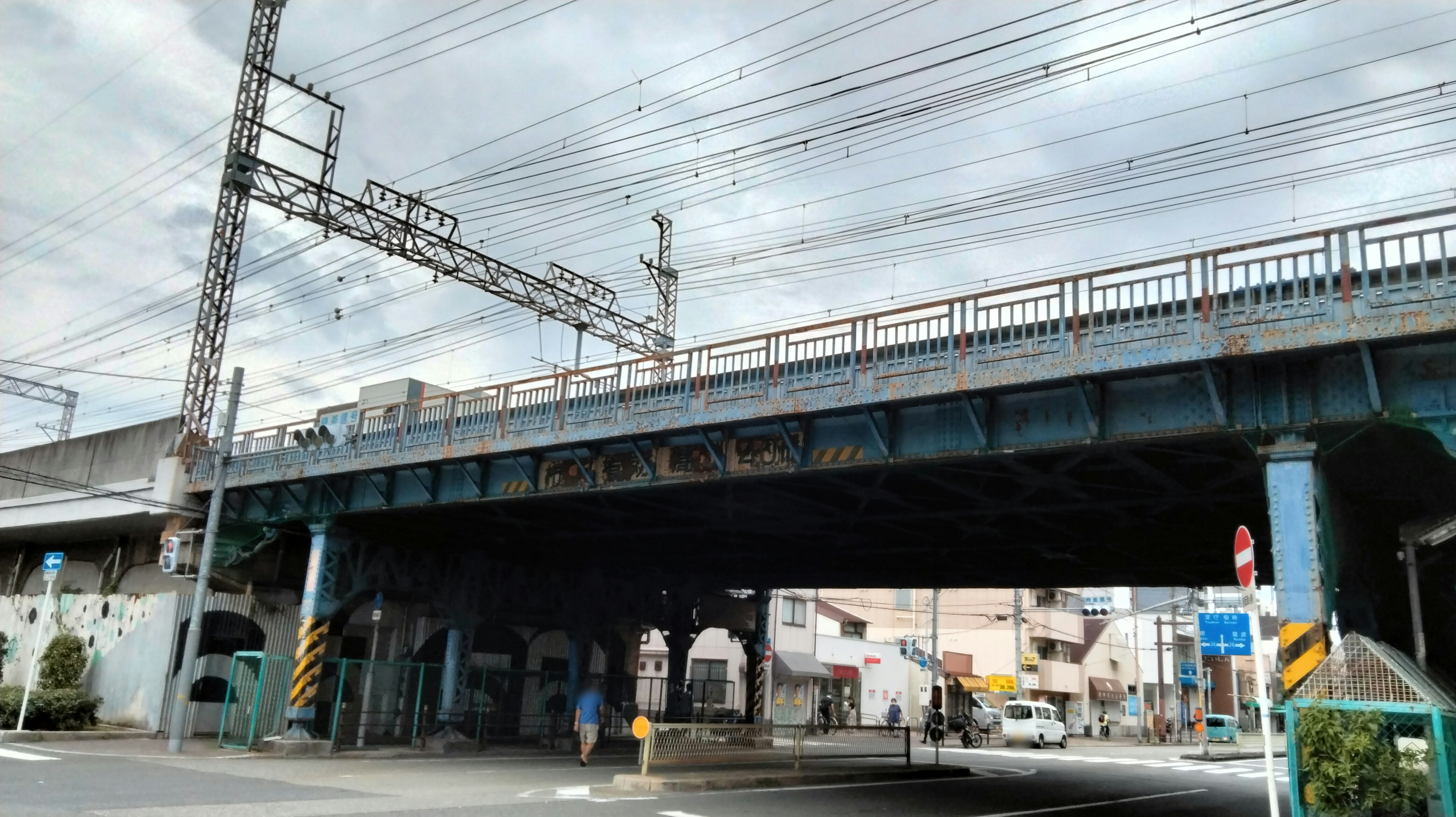 Carretera debajo de un puente ferroviario con paisaje urbano