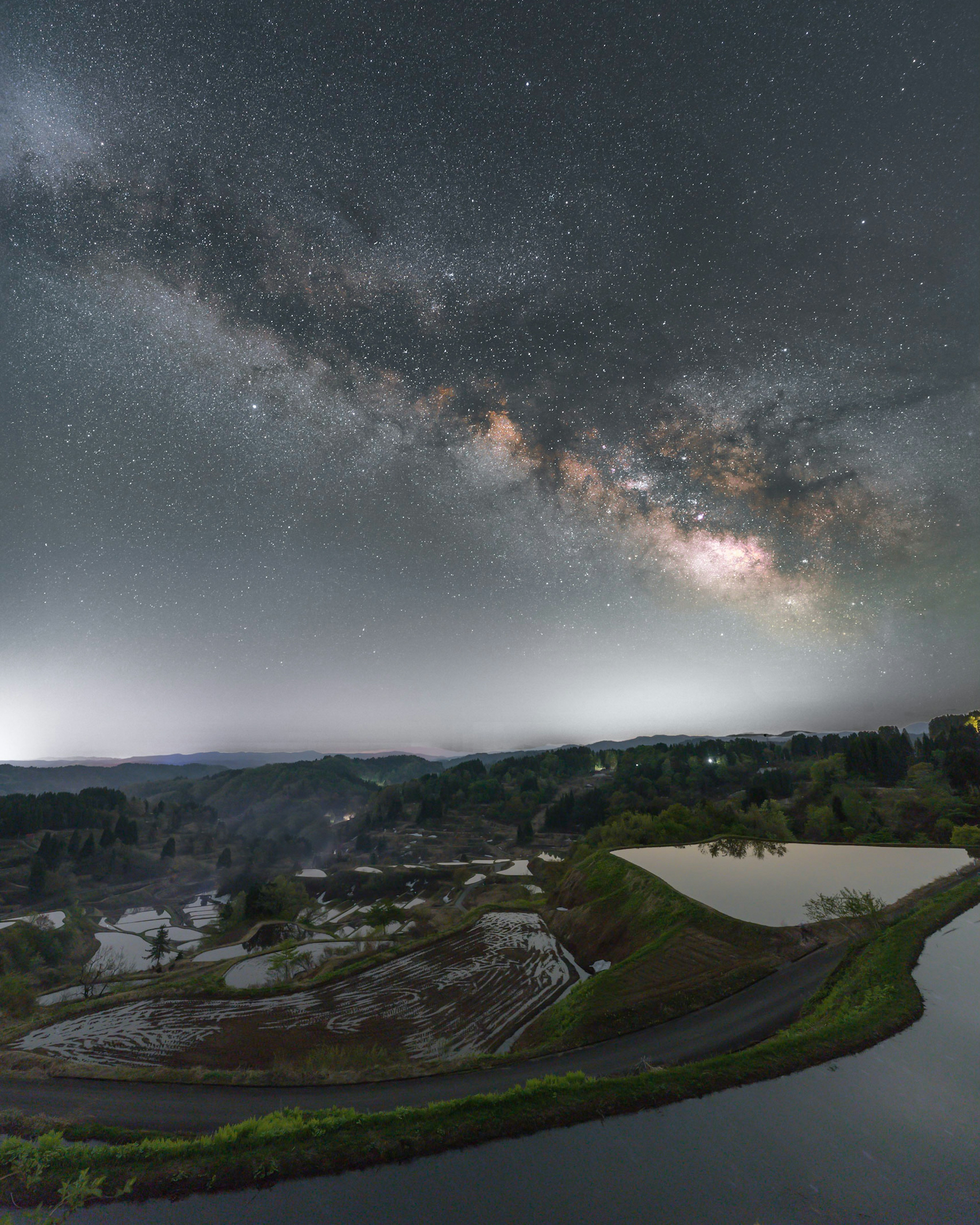 星空の下に広がる田園風景と銀河の帯