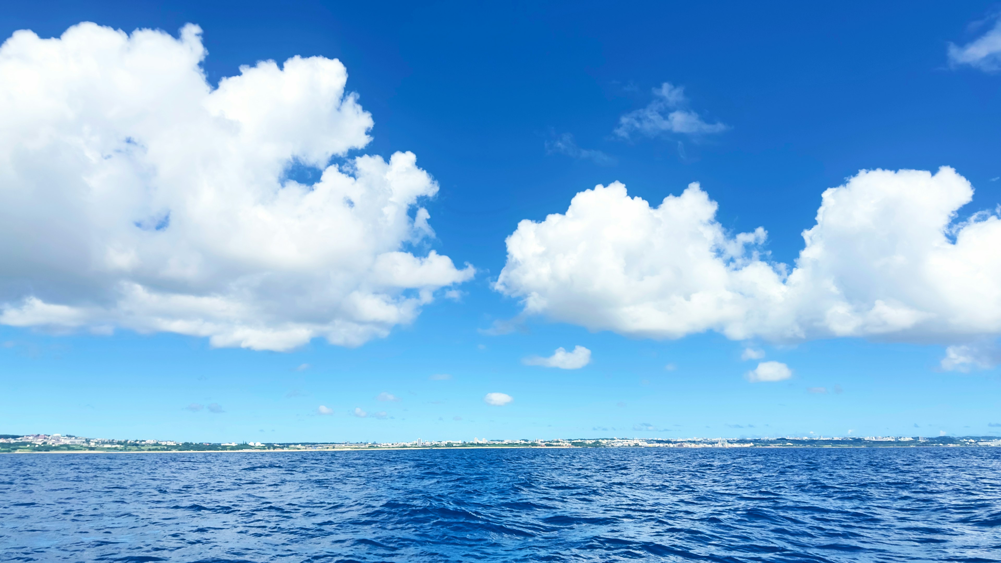 Paysage magnifique avec un océan bleu et des nuages blancs duveteux