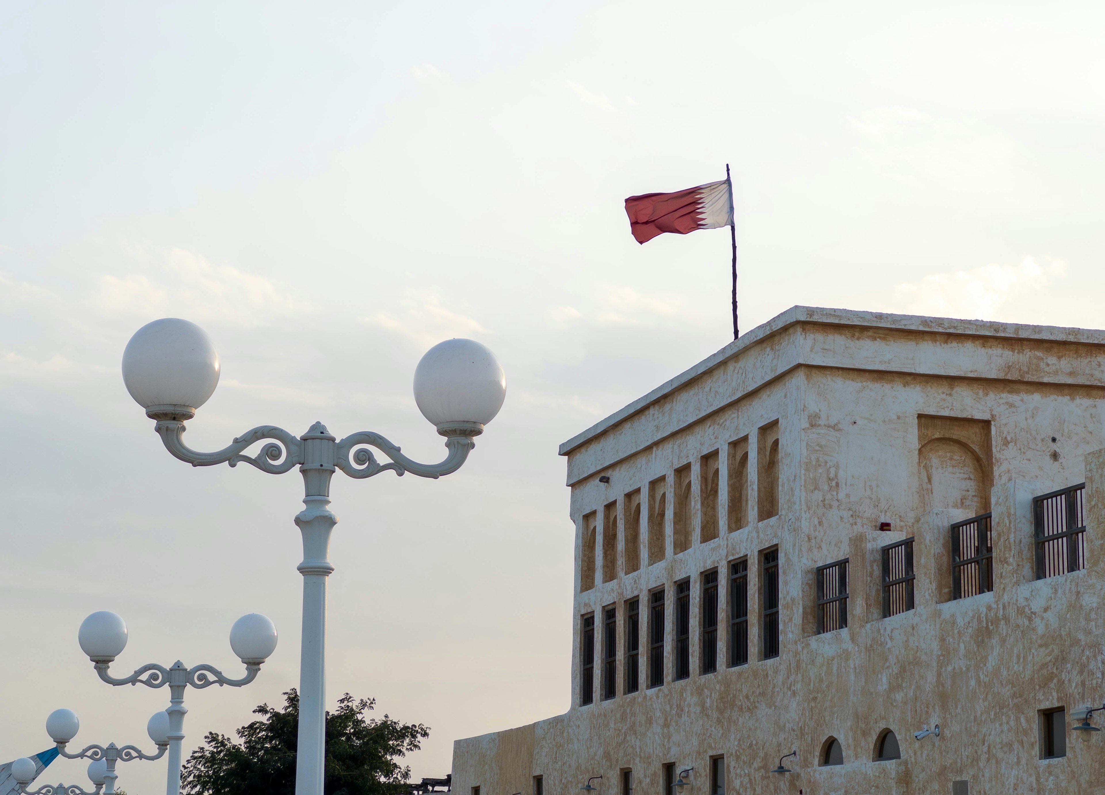 Historisches Gebäude mit roter Flagge und weißen Straßenlaternen