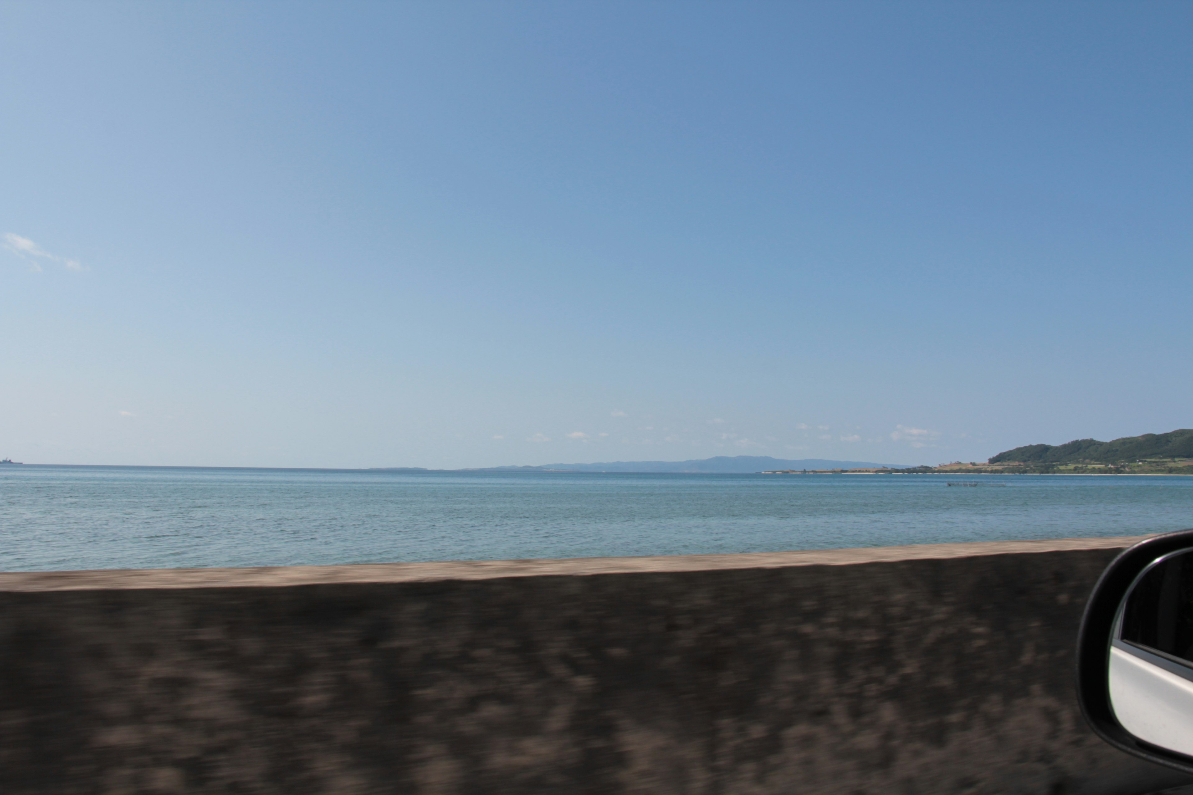 Scenic view of blue sea and sky from a car window