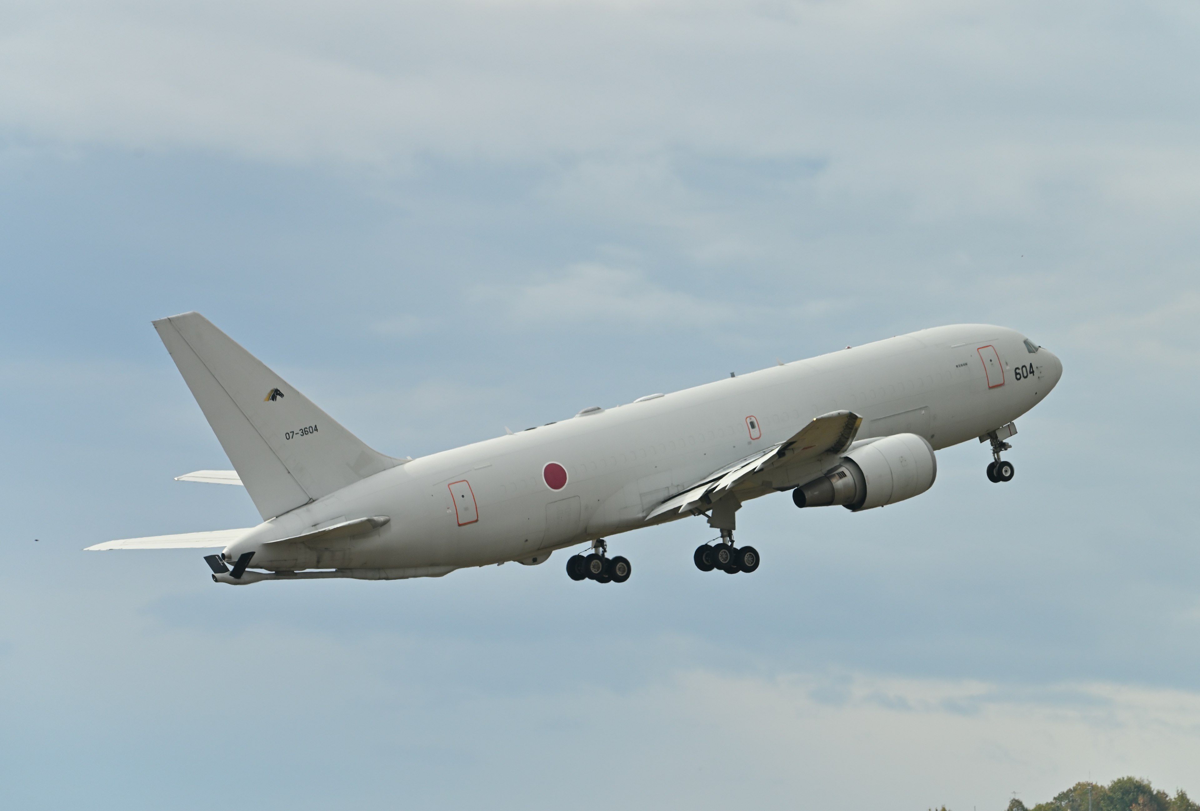 A white passenger airplane taking off into a blue sky