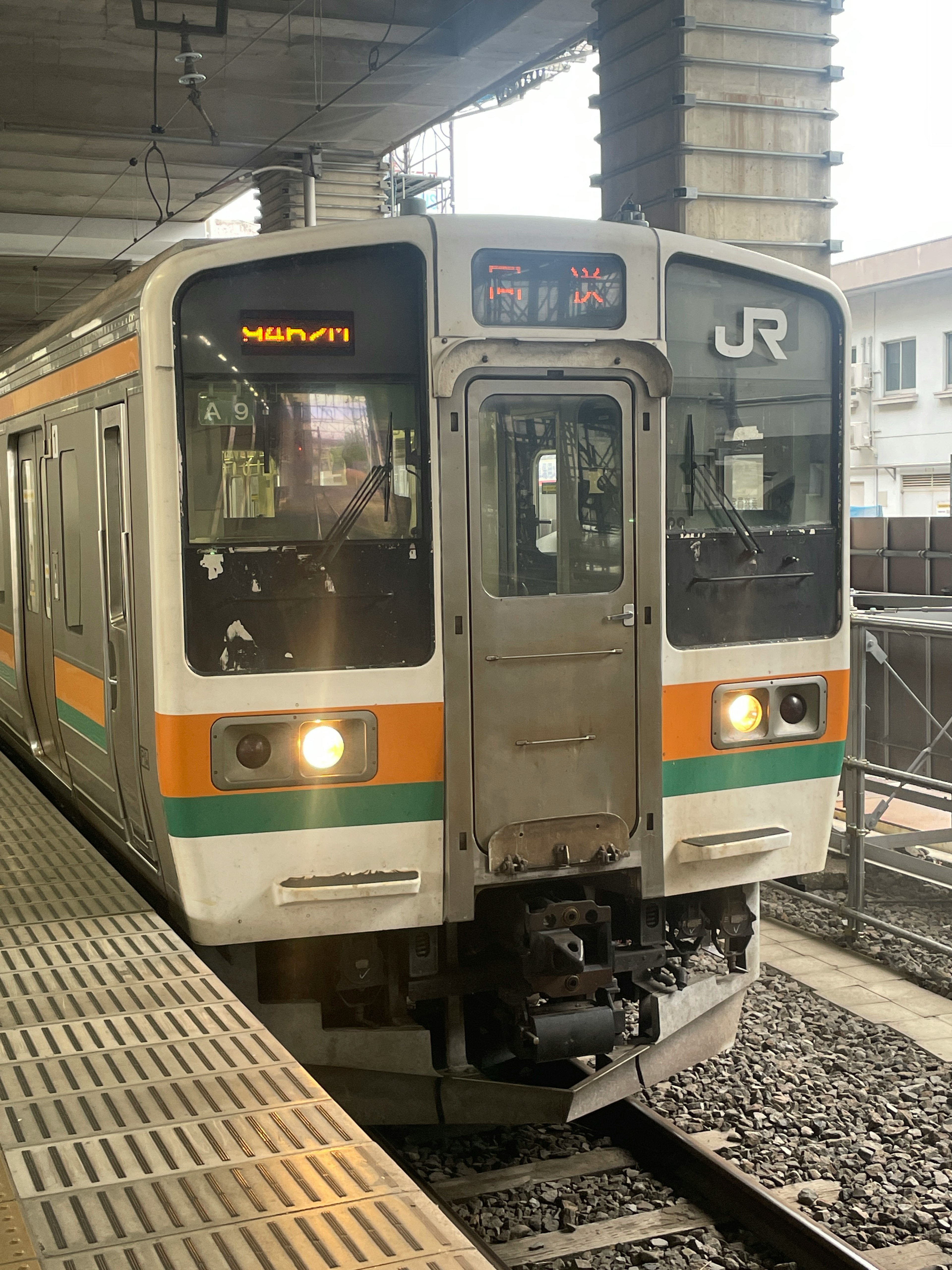 JR train arriving at a station with visible signage