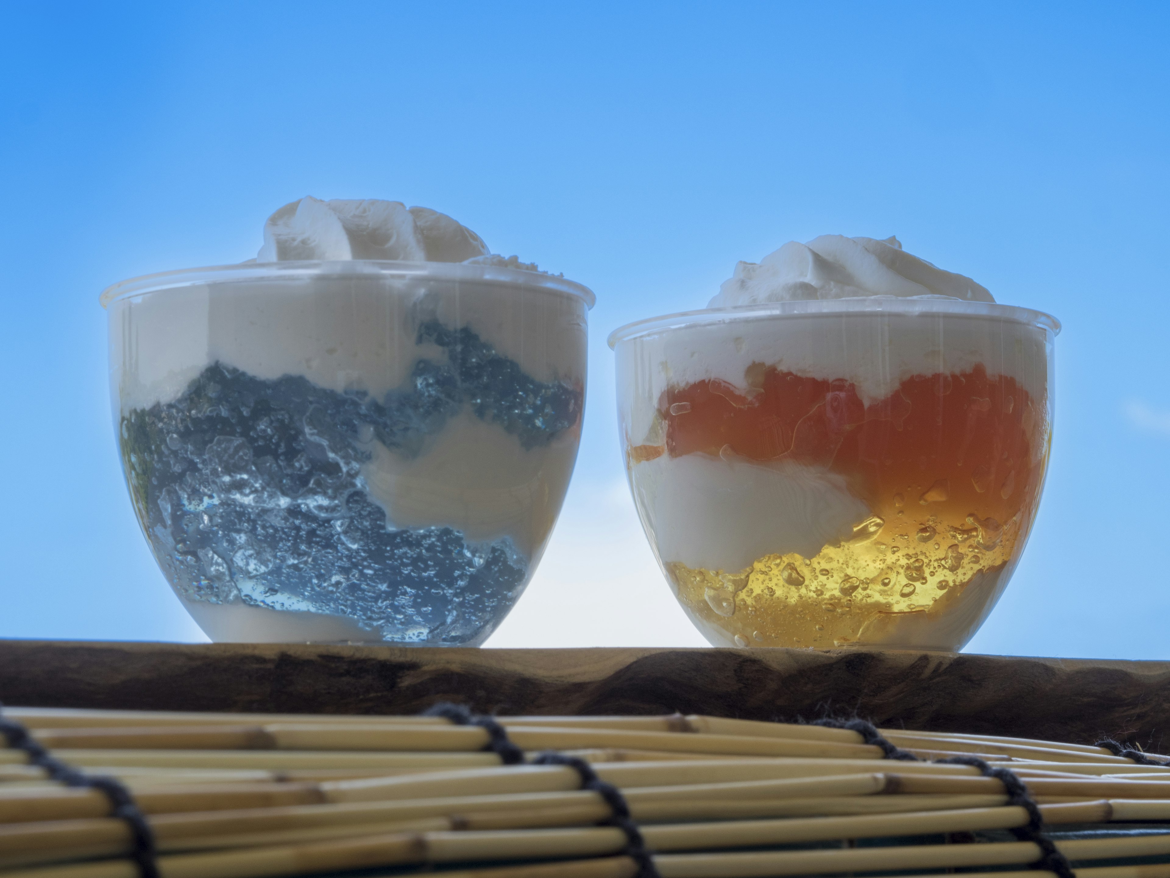 Dos copas de postre con capas azules y naranjas