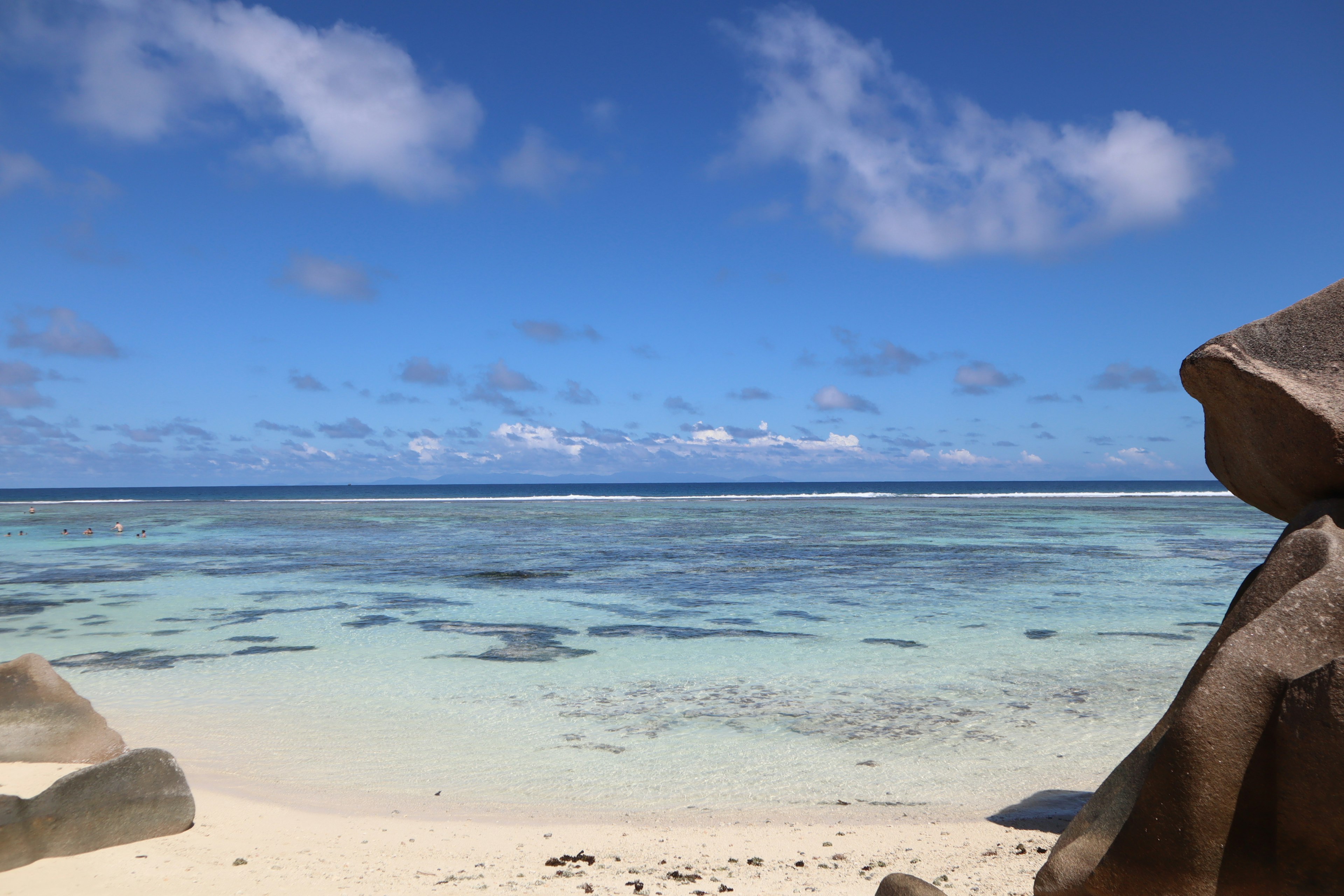 Vista escénica de playa con océano azul y arena blanca