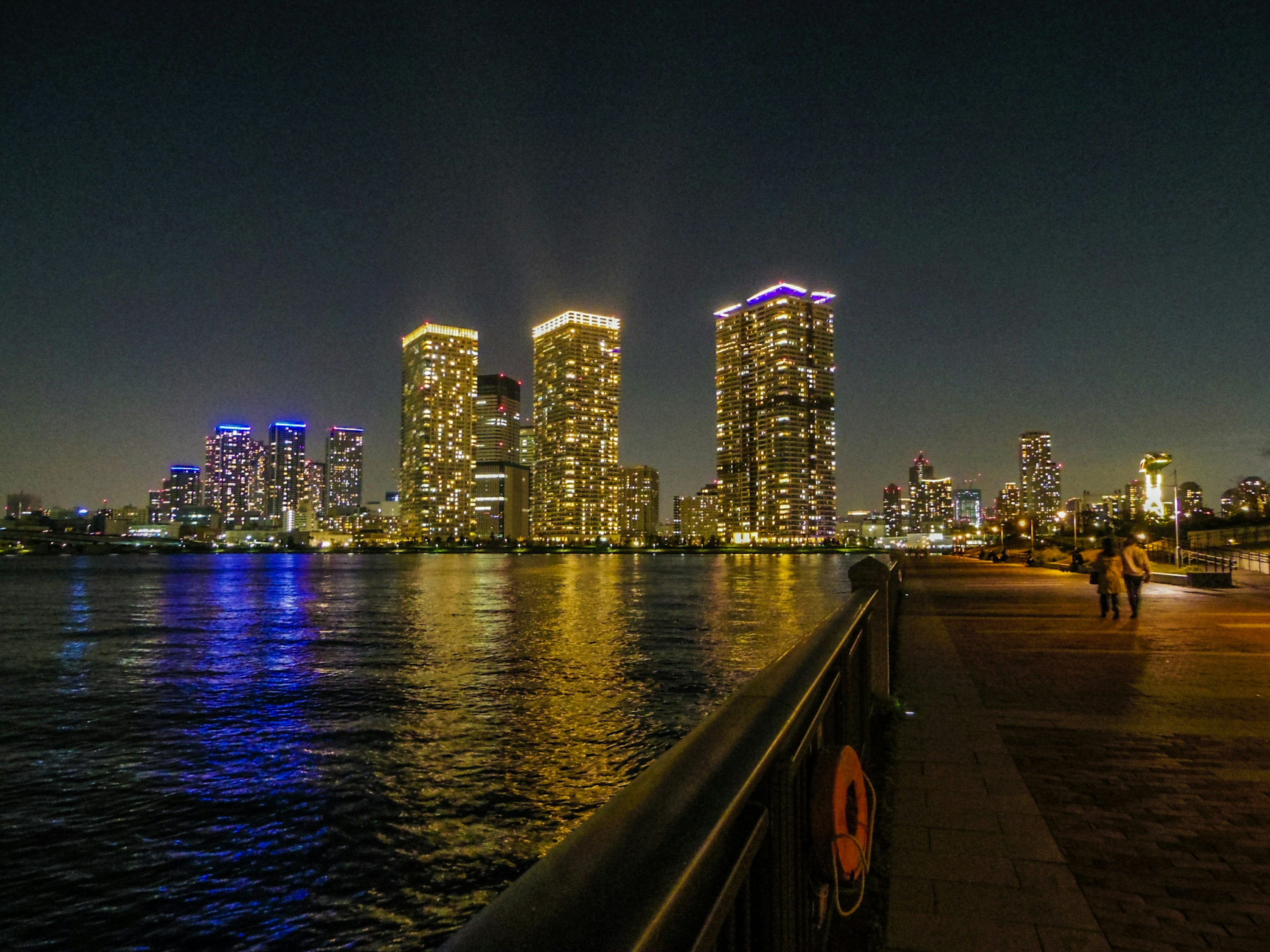 Nighttime cityscape with skyscrapers reflecting on water