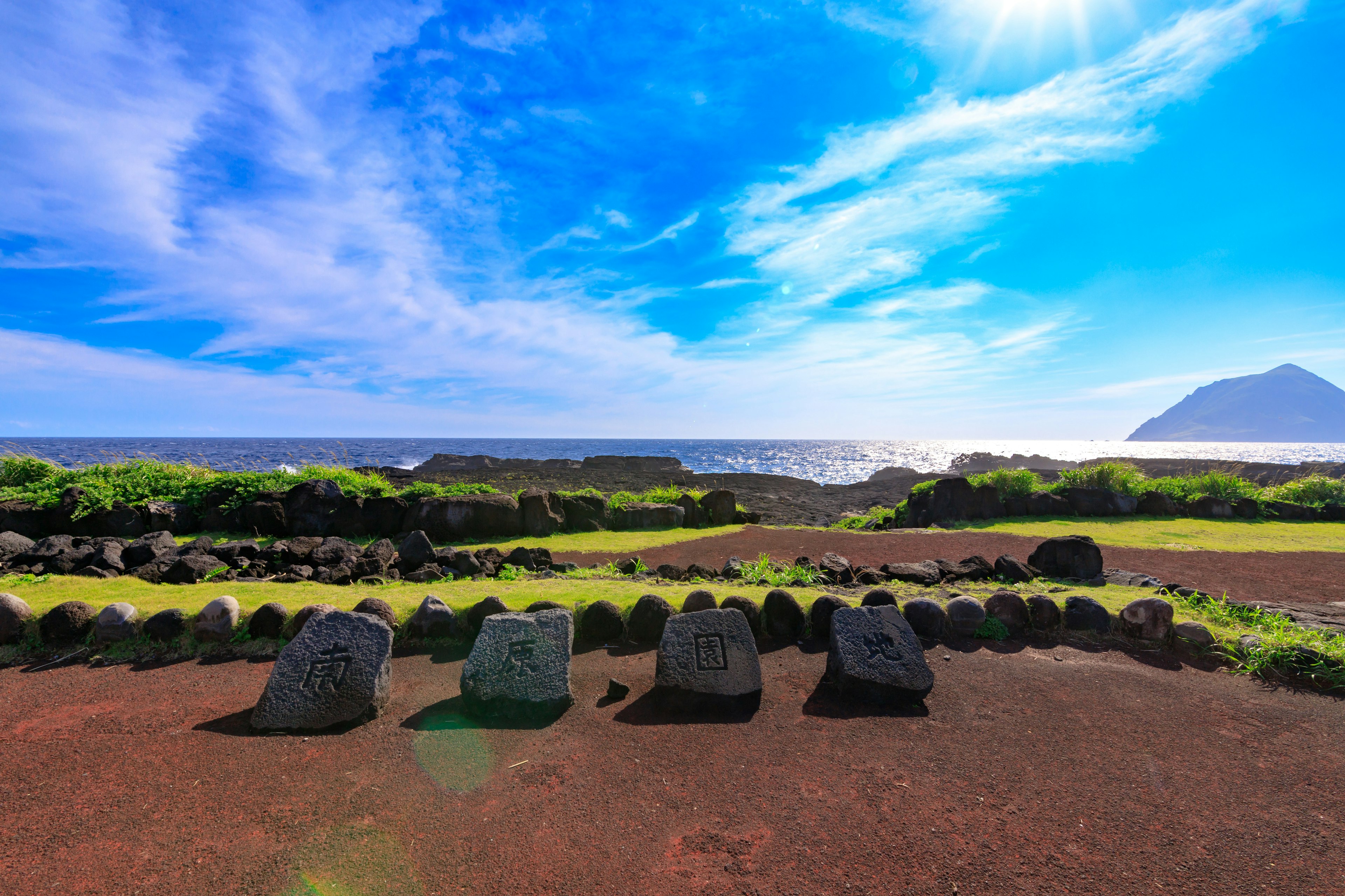 Row of stones with a backdrop of blue sky and ocean