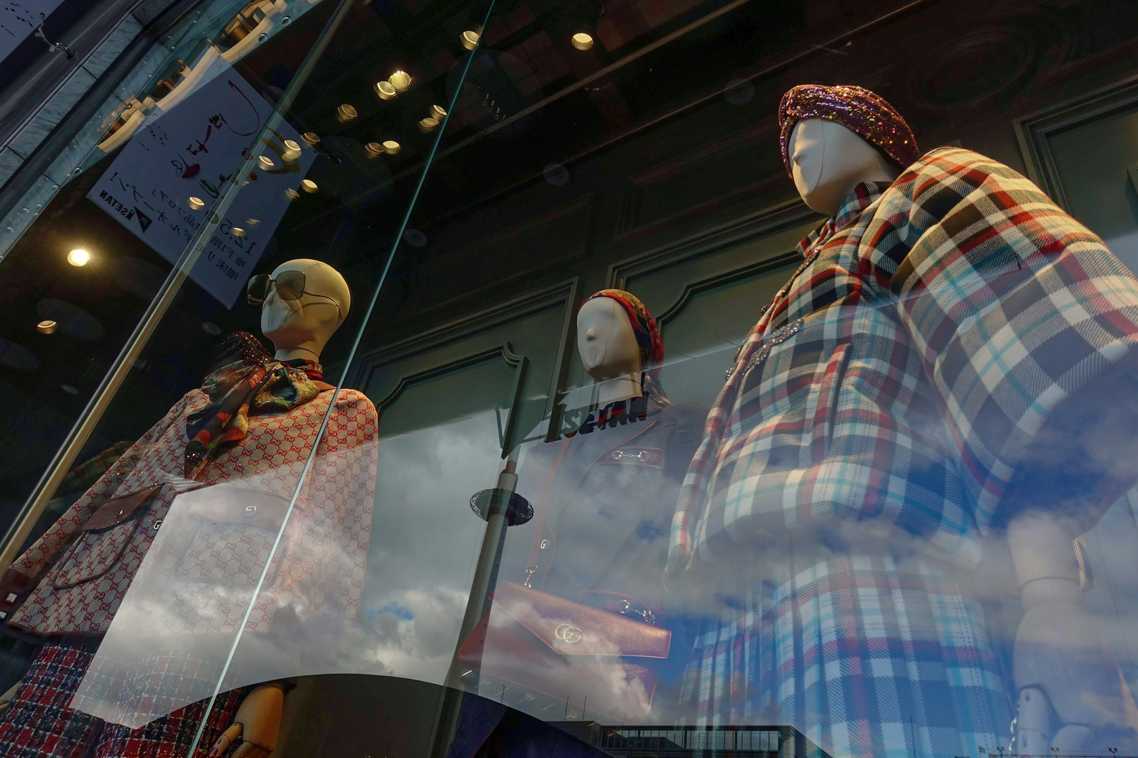 Mannequins in a storefront wearing plaid clothing