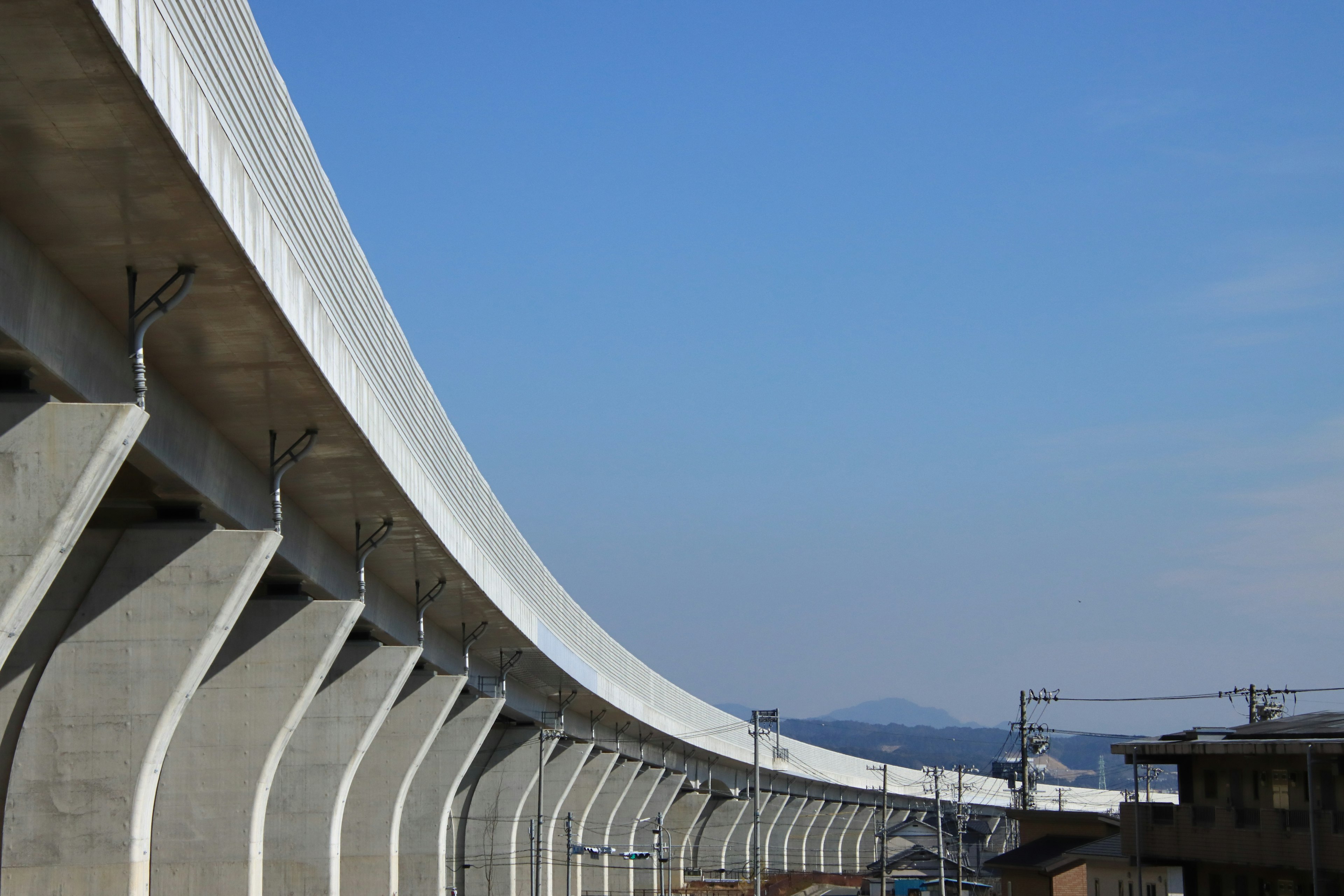 Struttura ferroviaria elevata curva contro un cielo blu