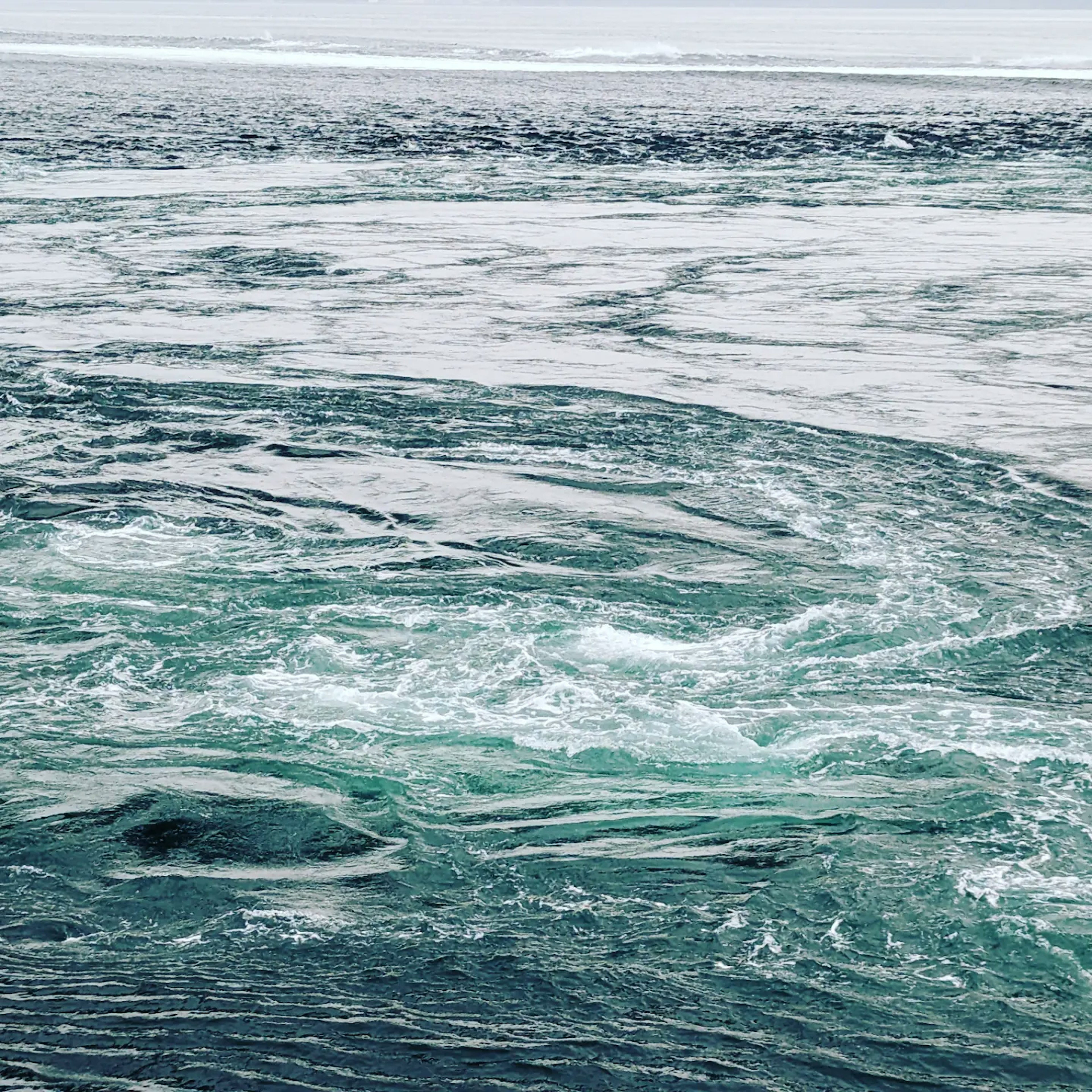 Arus laut berputar dan gelombang dalam nuansa biru dan hijau