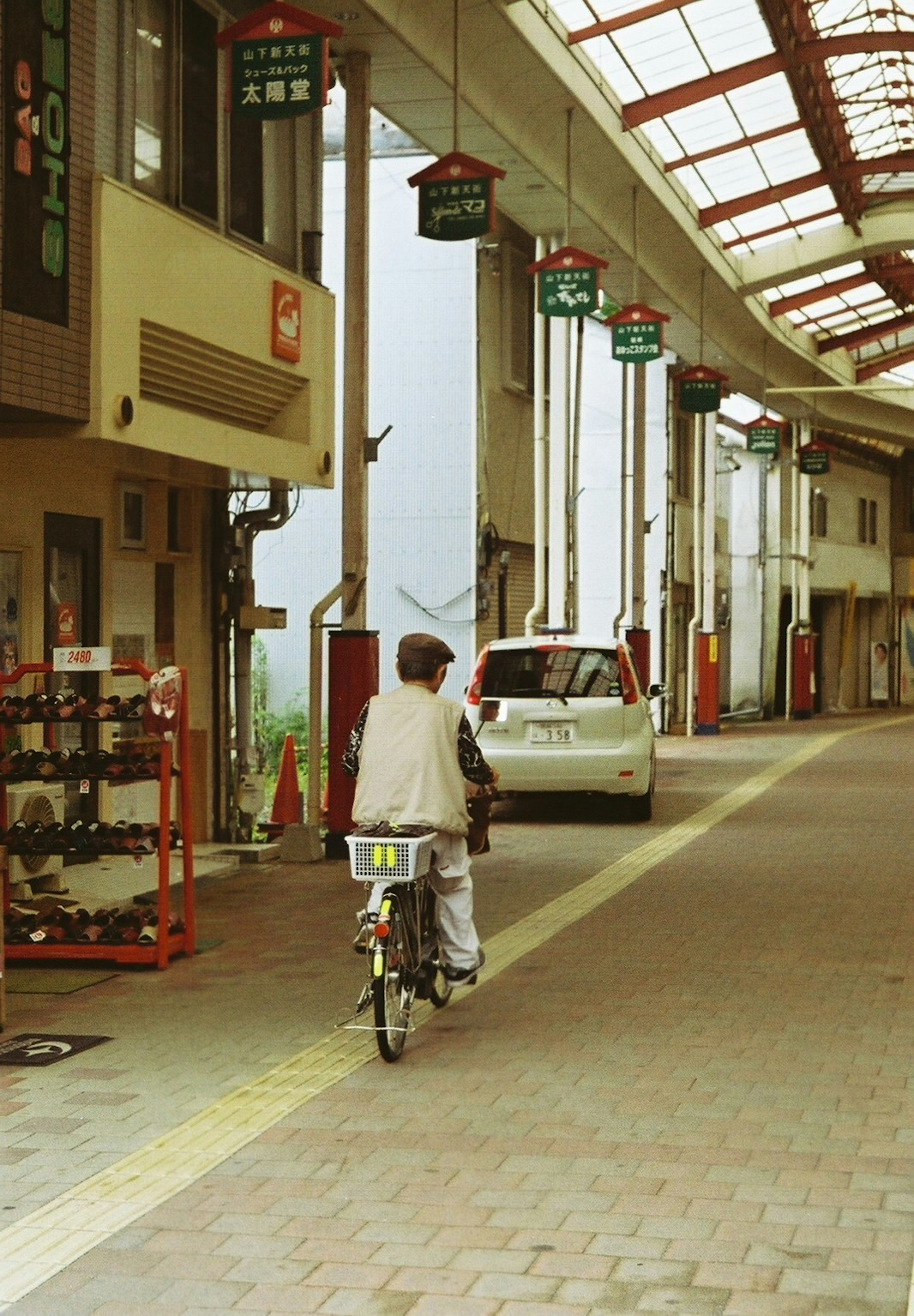 自転車に乗った人物が商店街を走る風景